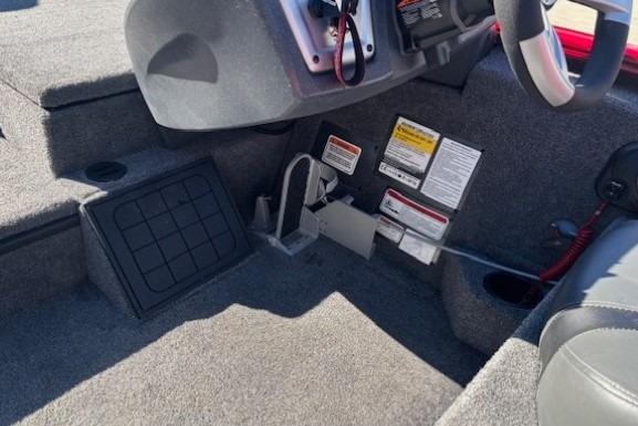 Interior of 2025 Tracker Savage 215 boat, featuring steering console and safety labels.