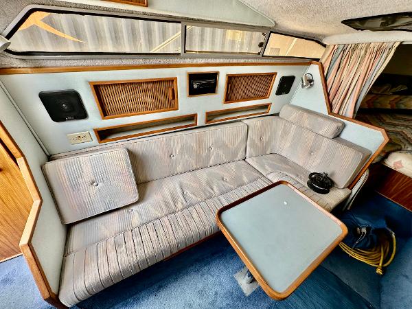 Interior of 1987 Sea Ray 270 Sundancer with striped seating and compact table.
