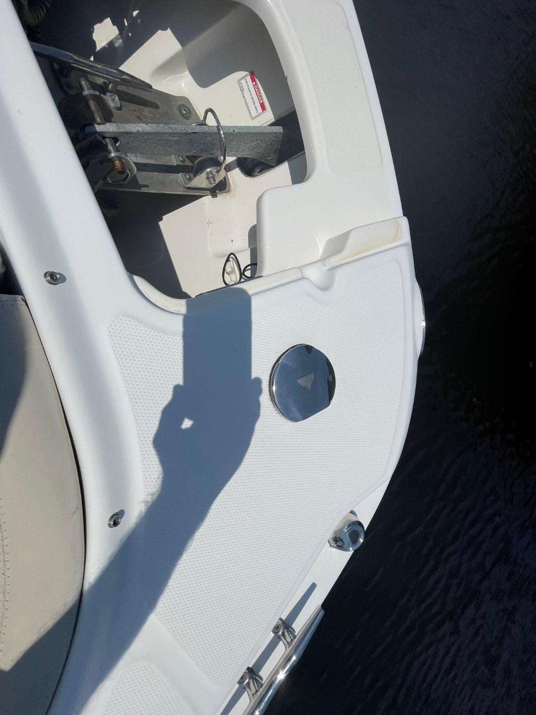 2016 Boston Whaler 270 Vantage boat deck with anchor compartment and water reflection.