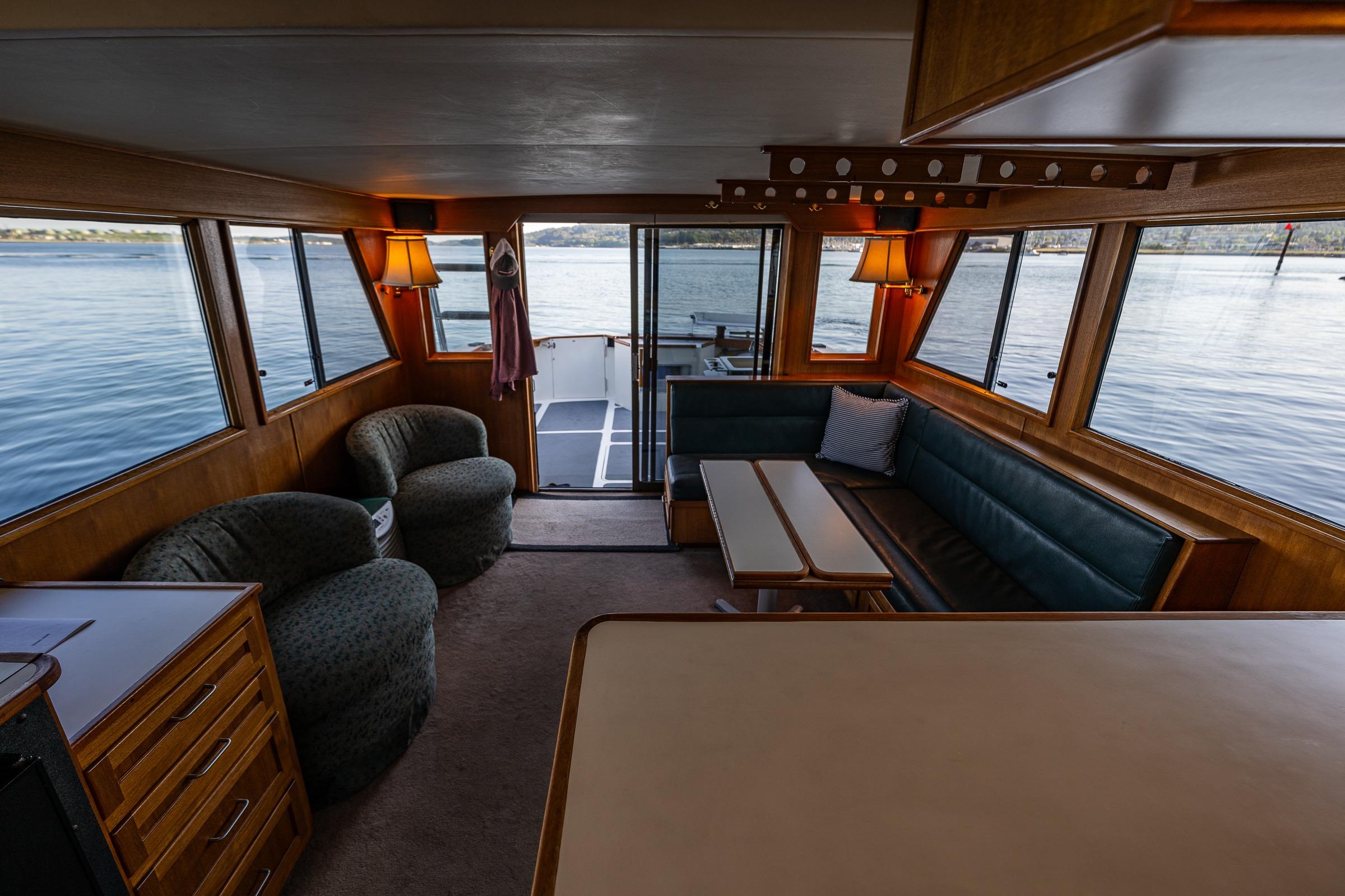 Cozy interior of 1989 Nordic 52 boat with seating and lake view.