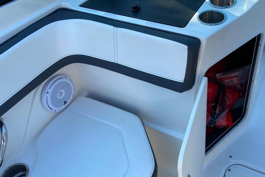 Interior of 2016 Sea Ray SPX 210 Outboard boat with seating and storage compartment.