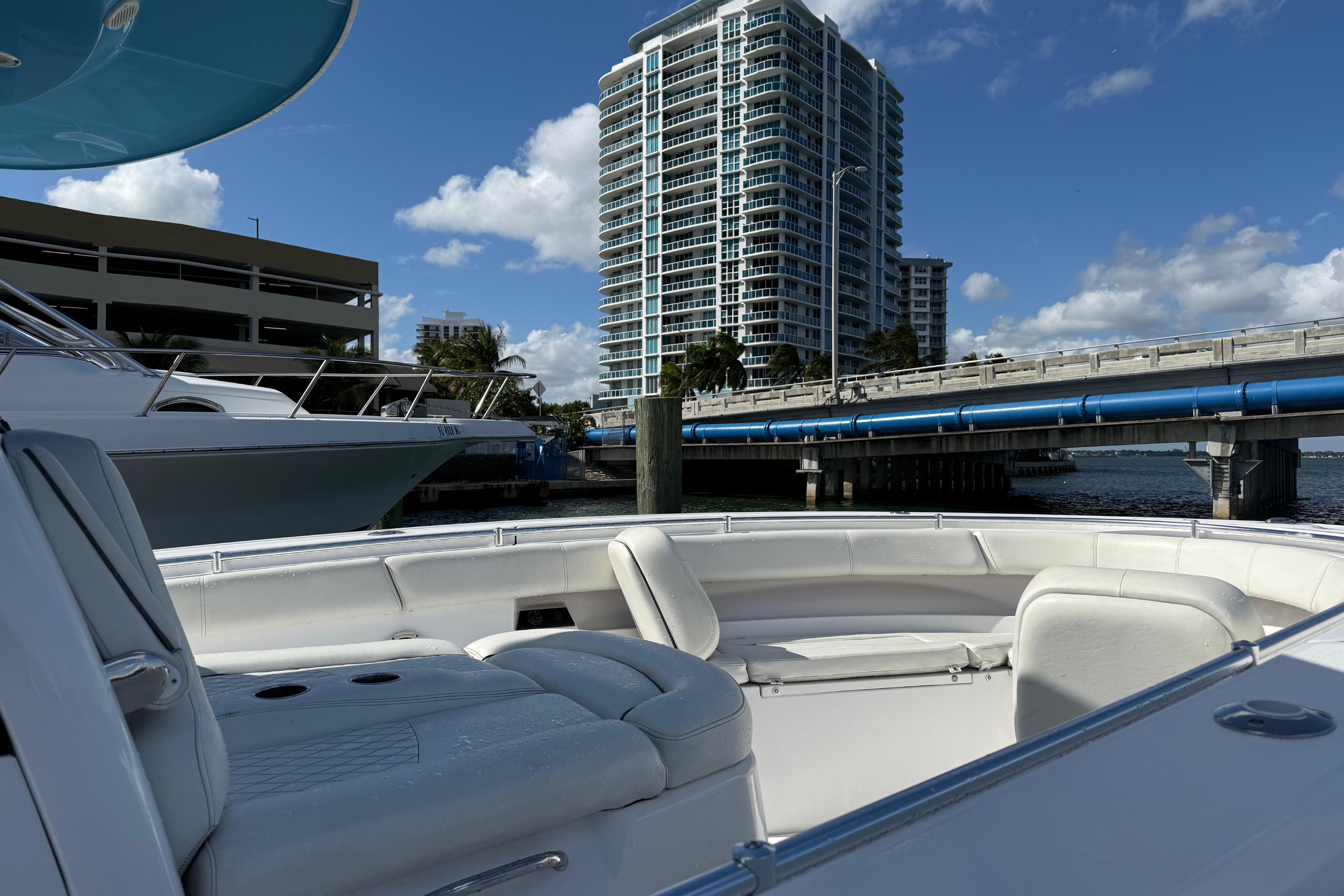 2020 Sportsman Open 352 Center Console boat docked near a bridge and high-rise building.
