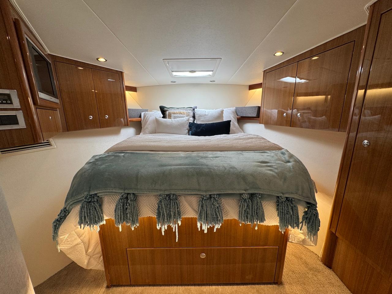 Luxurious bedroom interior of 2007 Viking 52 Convertibles yacht with elegant wood cabinetry.