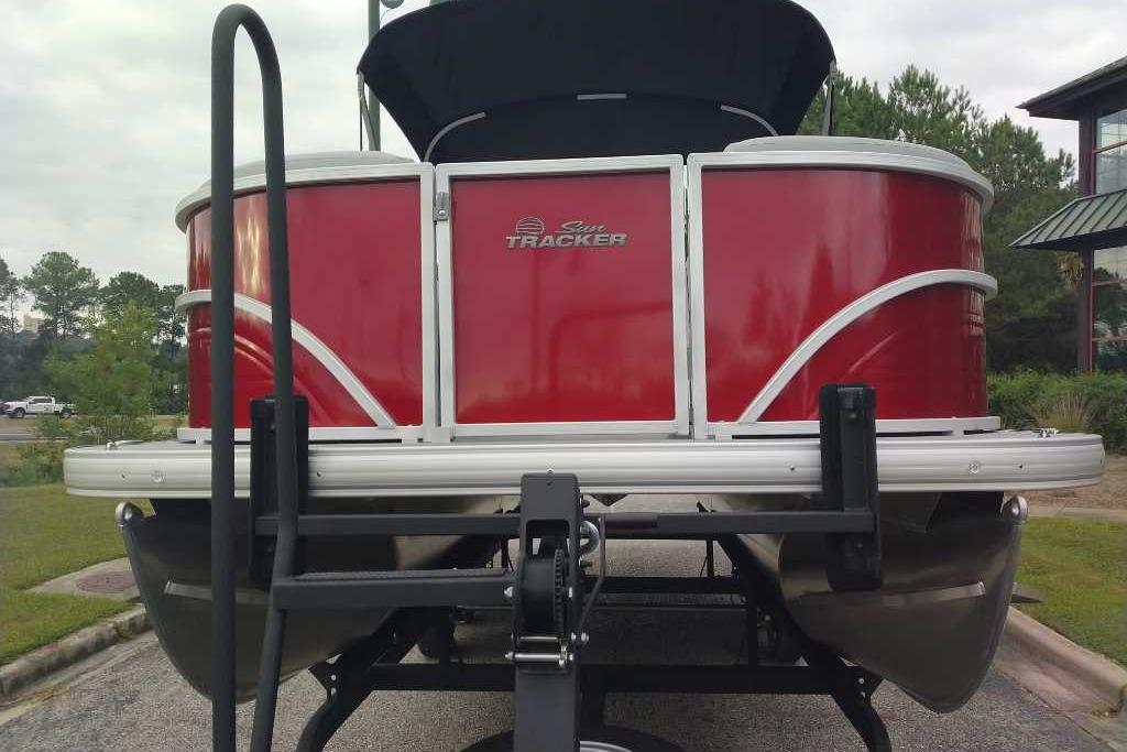 2026 Sun Tracker Party Barge 20 DLX pontoon boat, red exterior, parked on trailer.