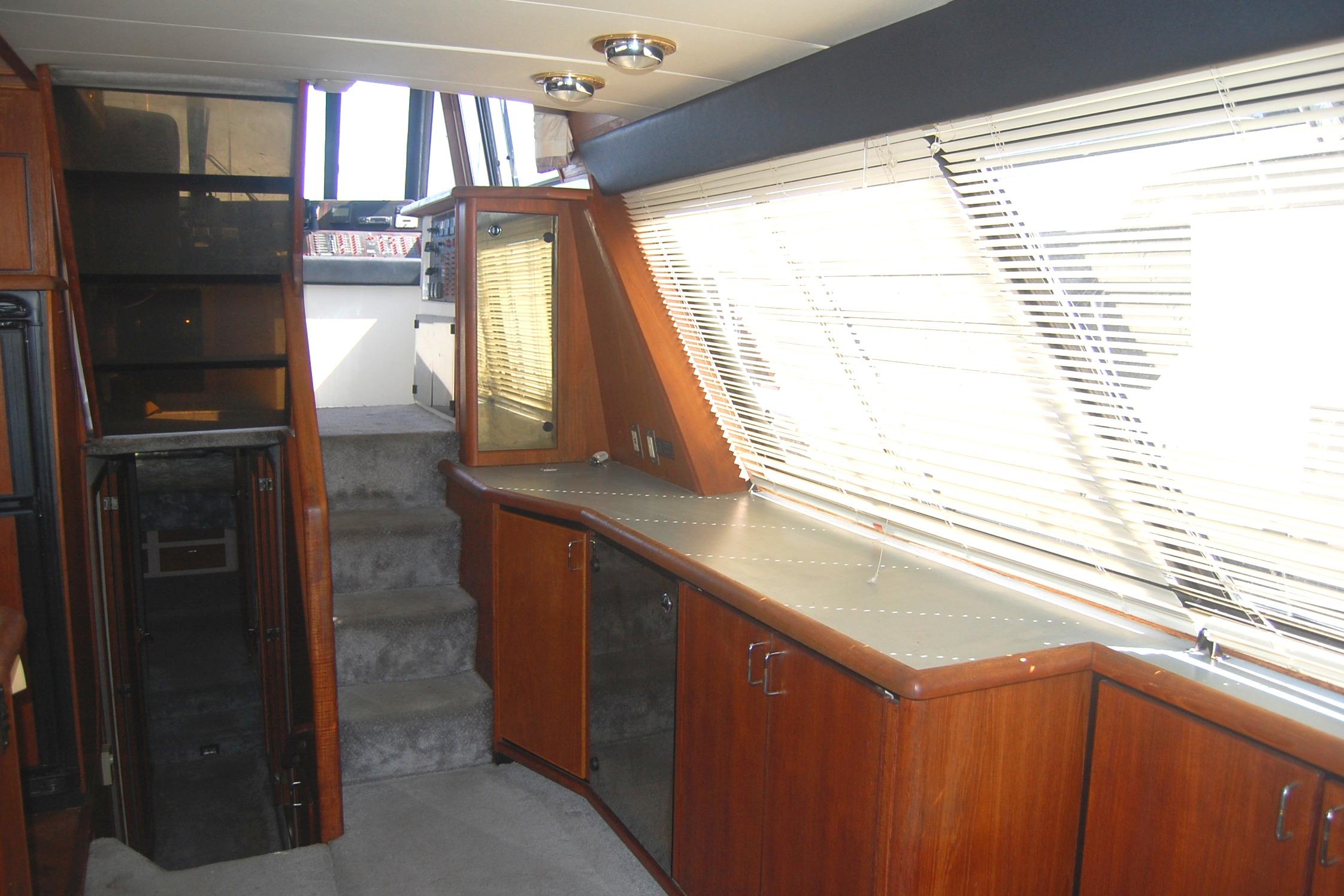 Interior of 1992 Bayliner 4588 Pilothouse MY with wooden cabinetry and large windows.