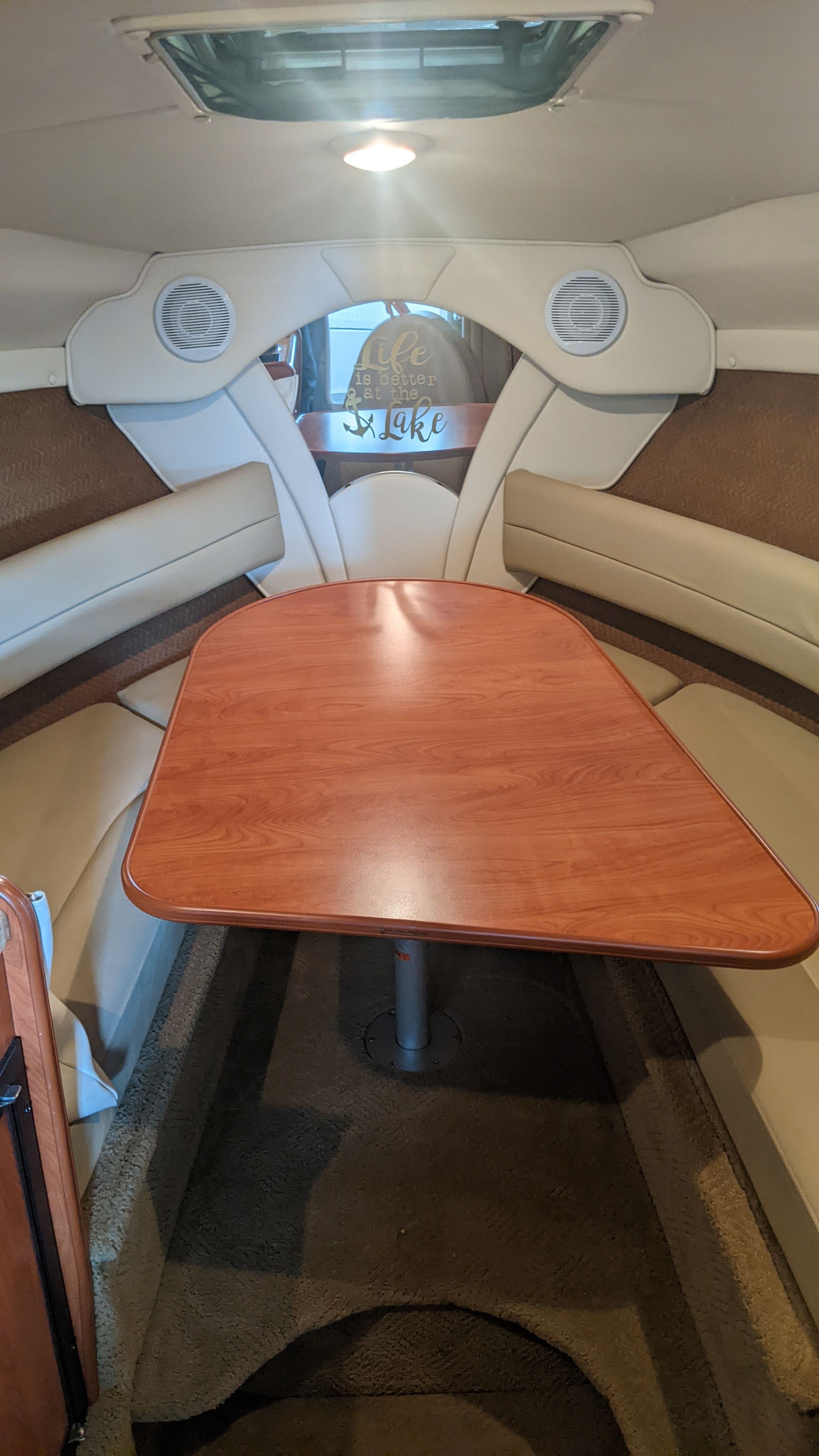 Interior of a 2006 Rinker 250 EC boat with wooden table.