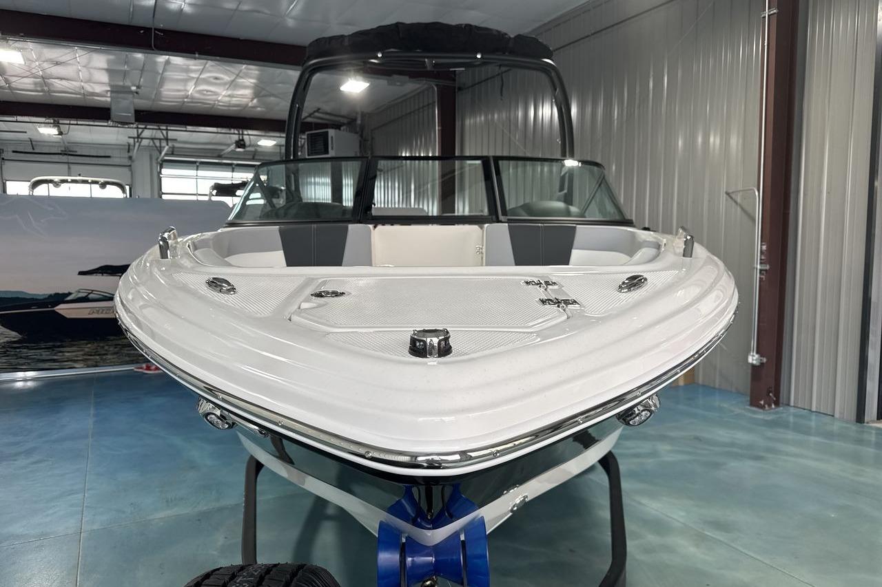 A 2026 Chaparral 23 SSi boat is indoors. It features a sleek, modern design.