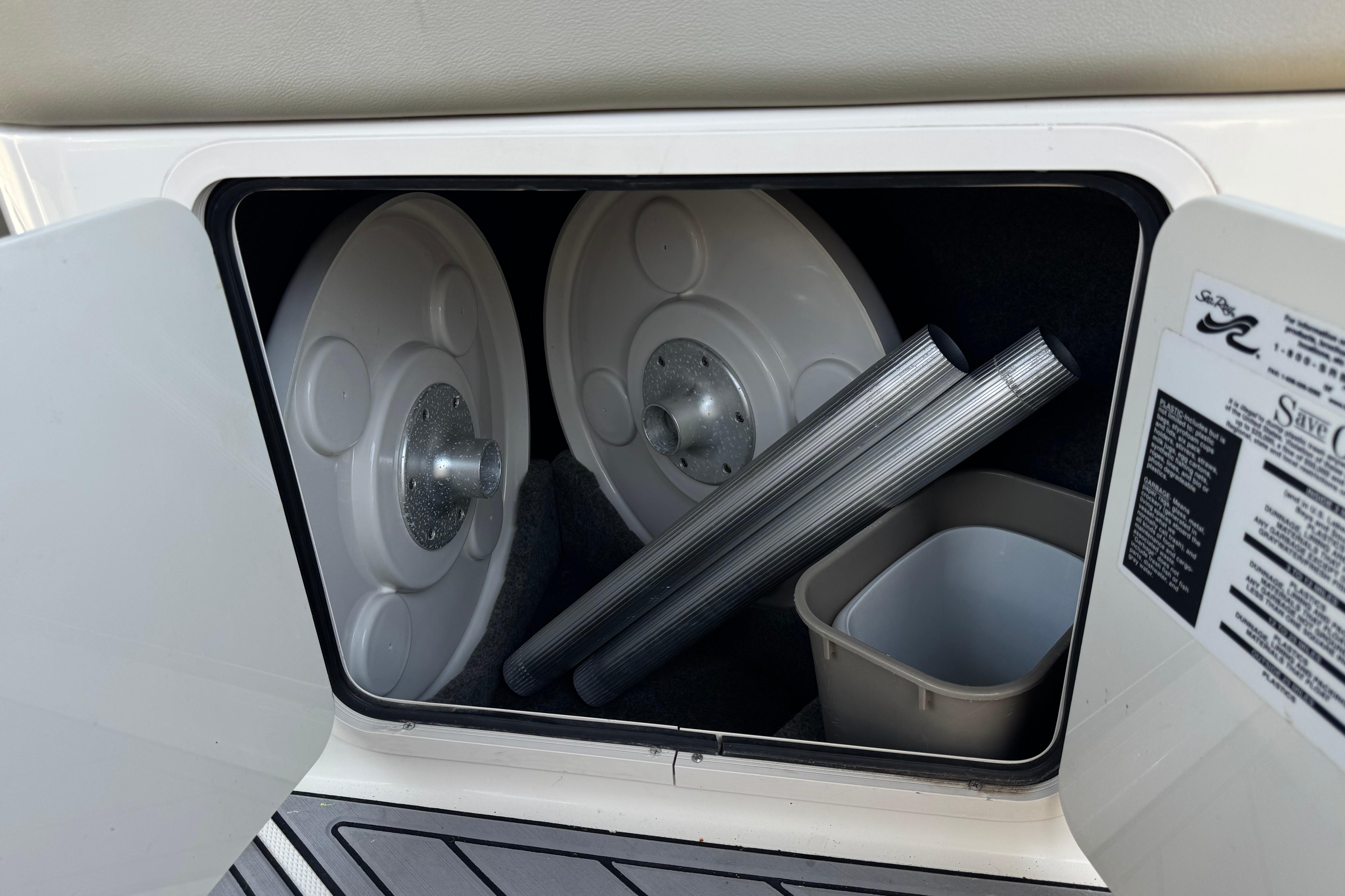 Storage compartment in a 2007 Sea Ray 240 Sundeck with accessories and manuals.