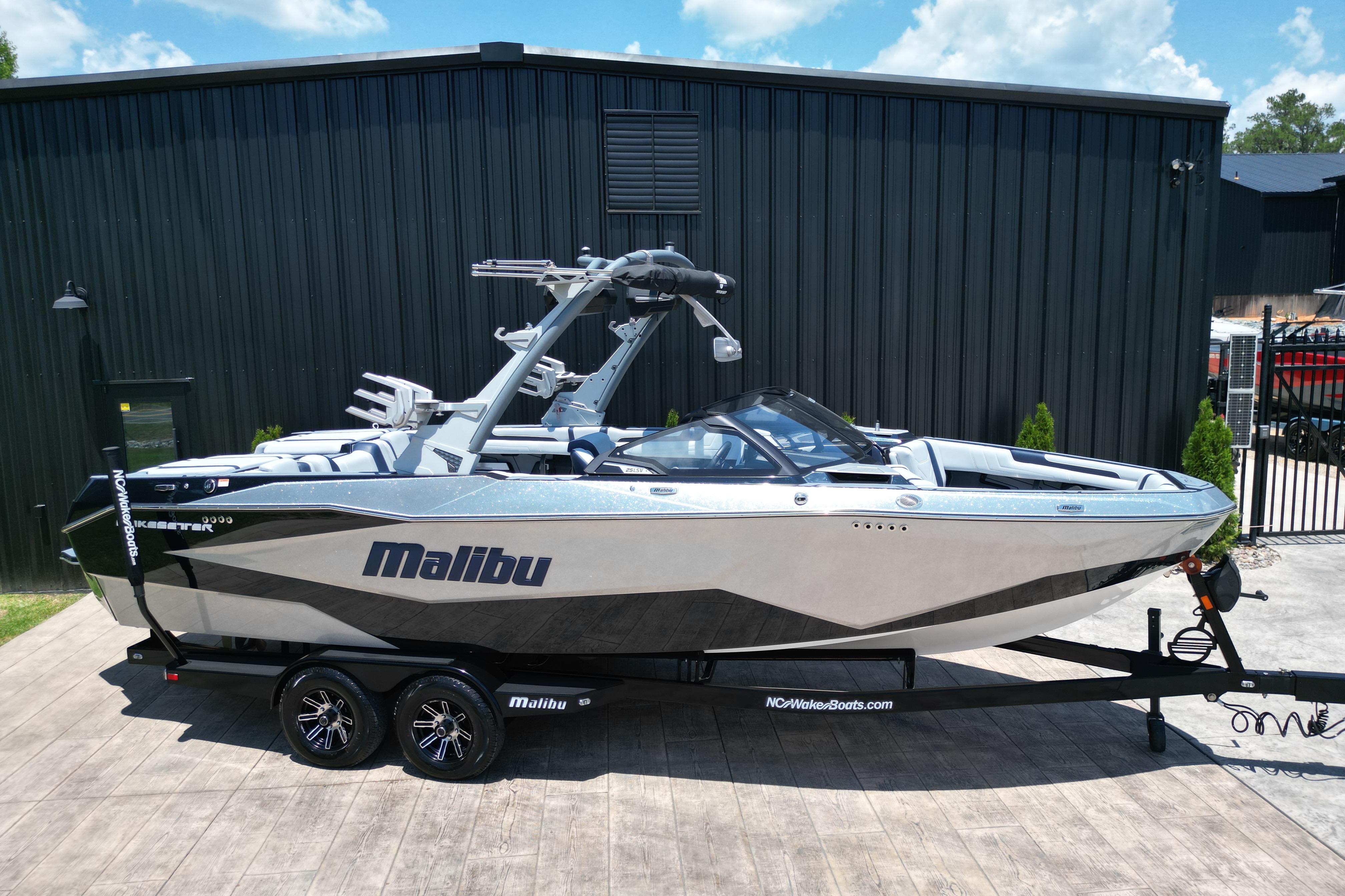 2025 Malibu Wakesetter 25 LSV boat on trailer, parked outdoors.