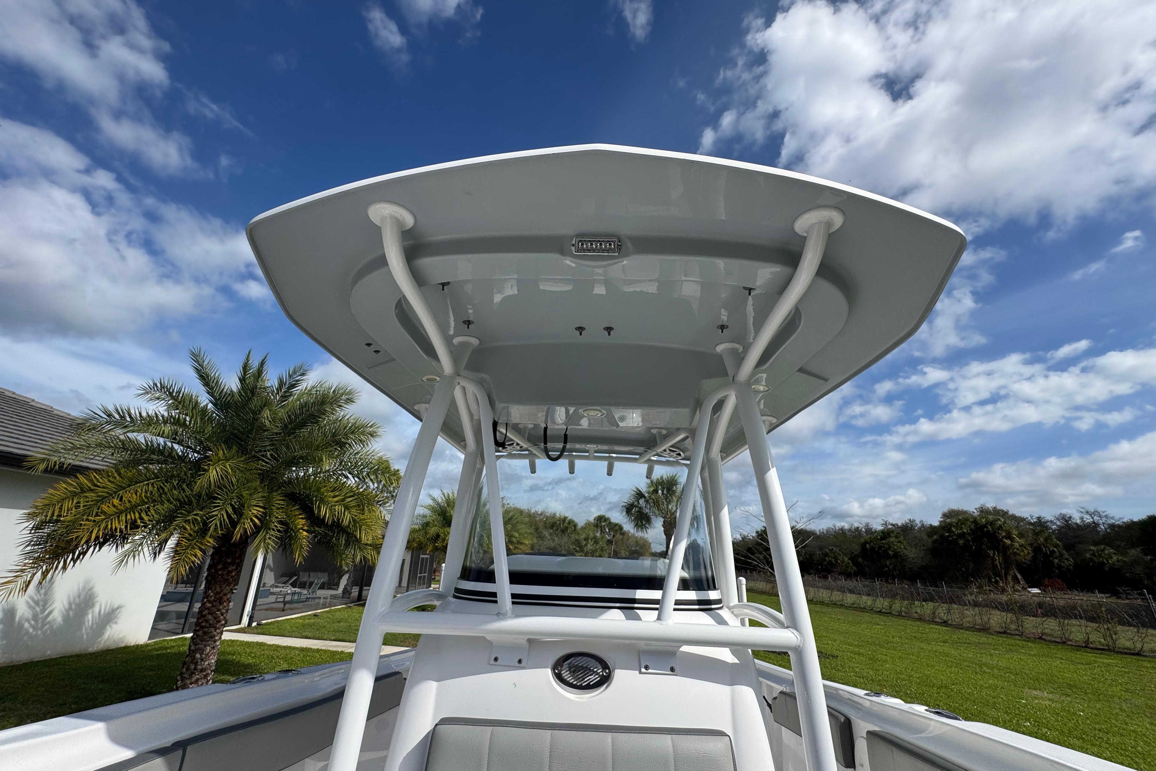 2022 Aquasport 2500 Center Console boat with T-top against a blue sky backdrop.