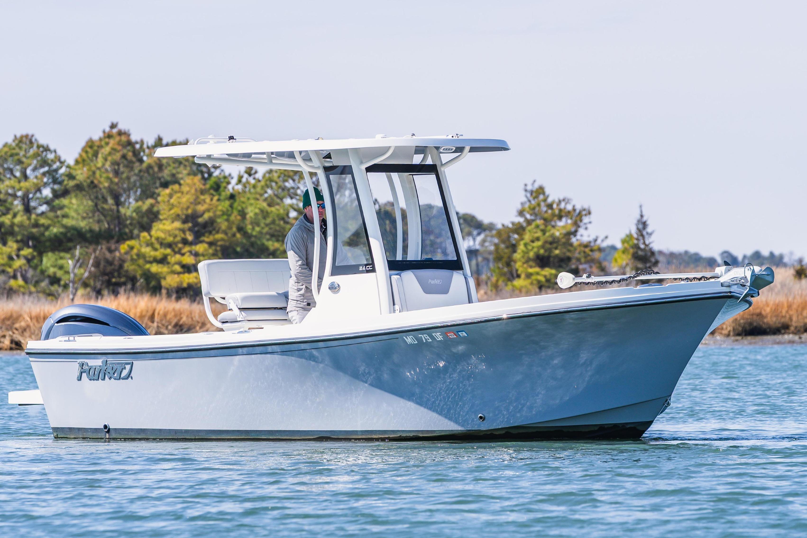 2023 Parker 2400 boat cruising on a serene lake with trees in the background.