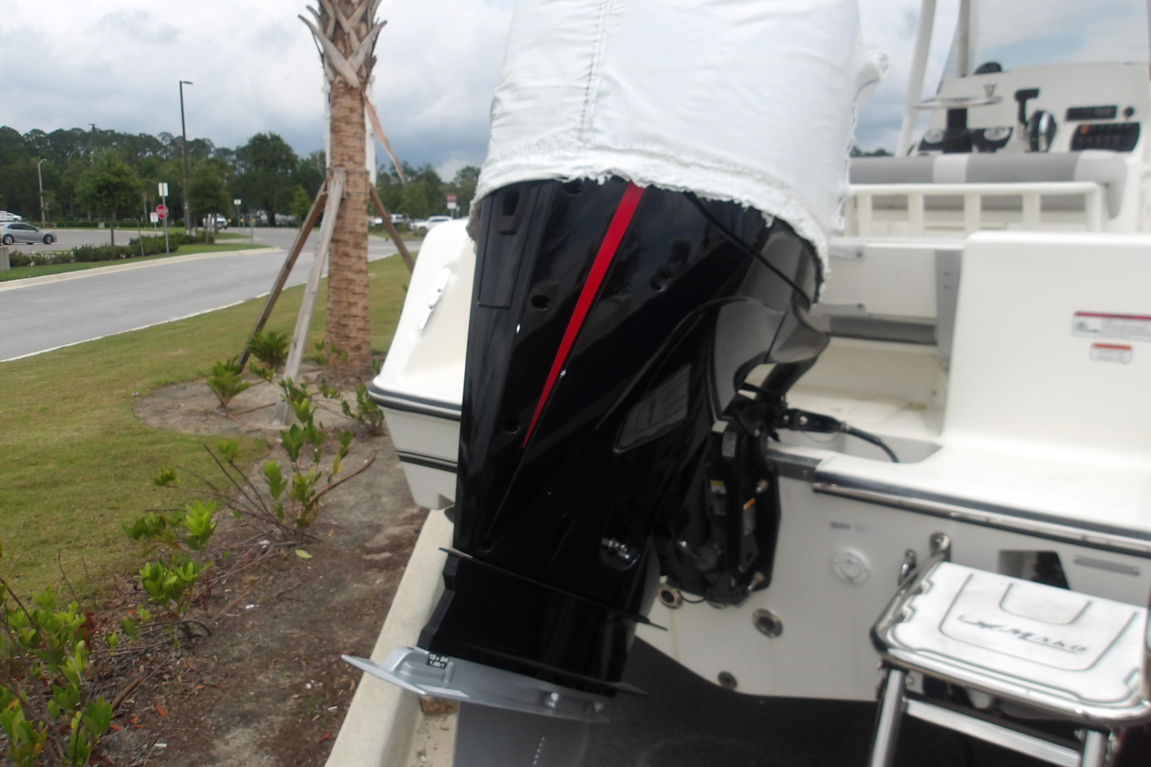 2025 Mako 214 Center Console boat with covered outboard motor in a parking area.