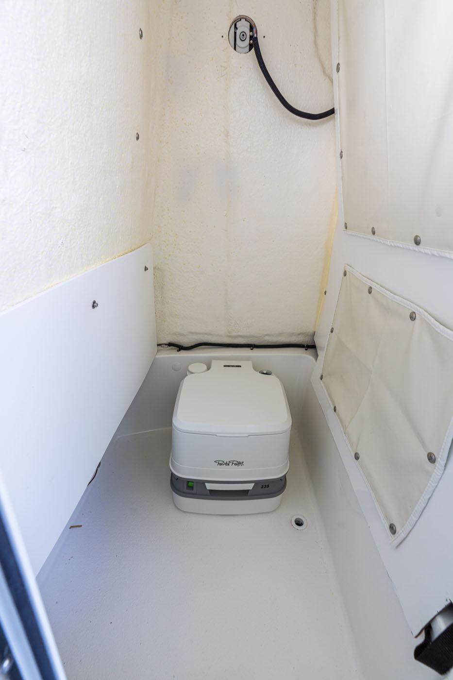 2025 NauticStar 231 Hybrid boat interior with portable toilet.