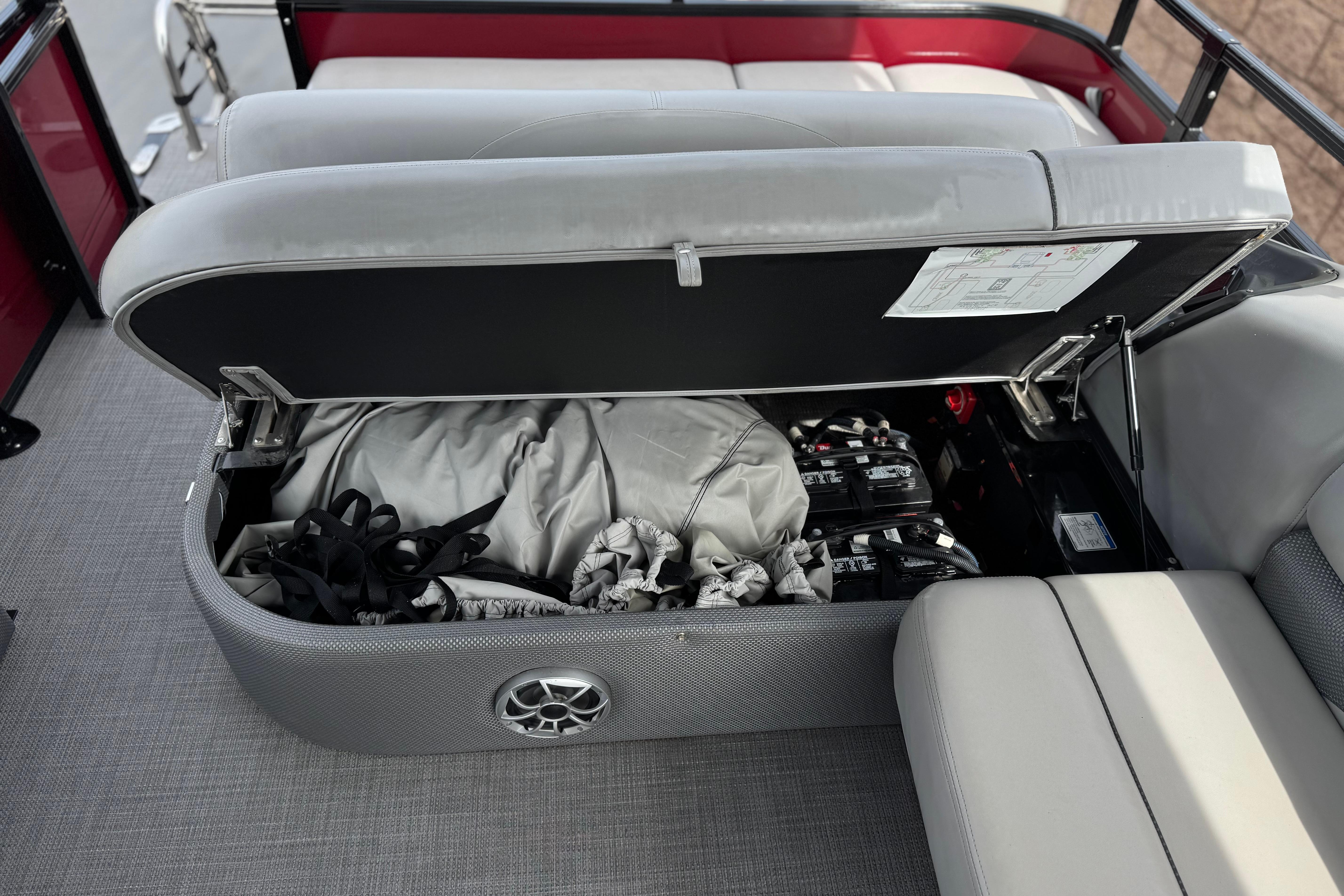 Open storage compartment in 2022 Regency 250 DL3 boat, revealing equipment and batteries.
