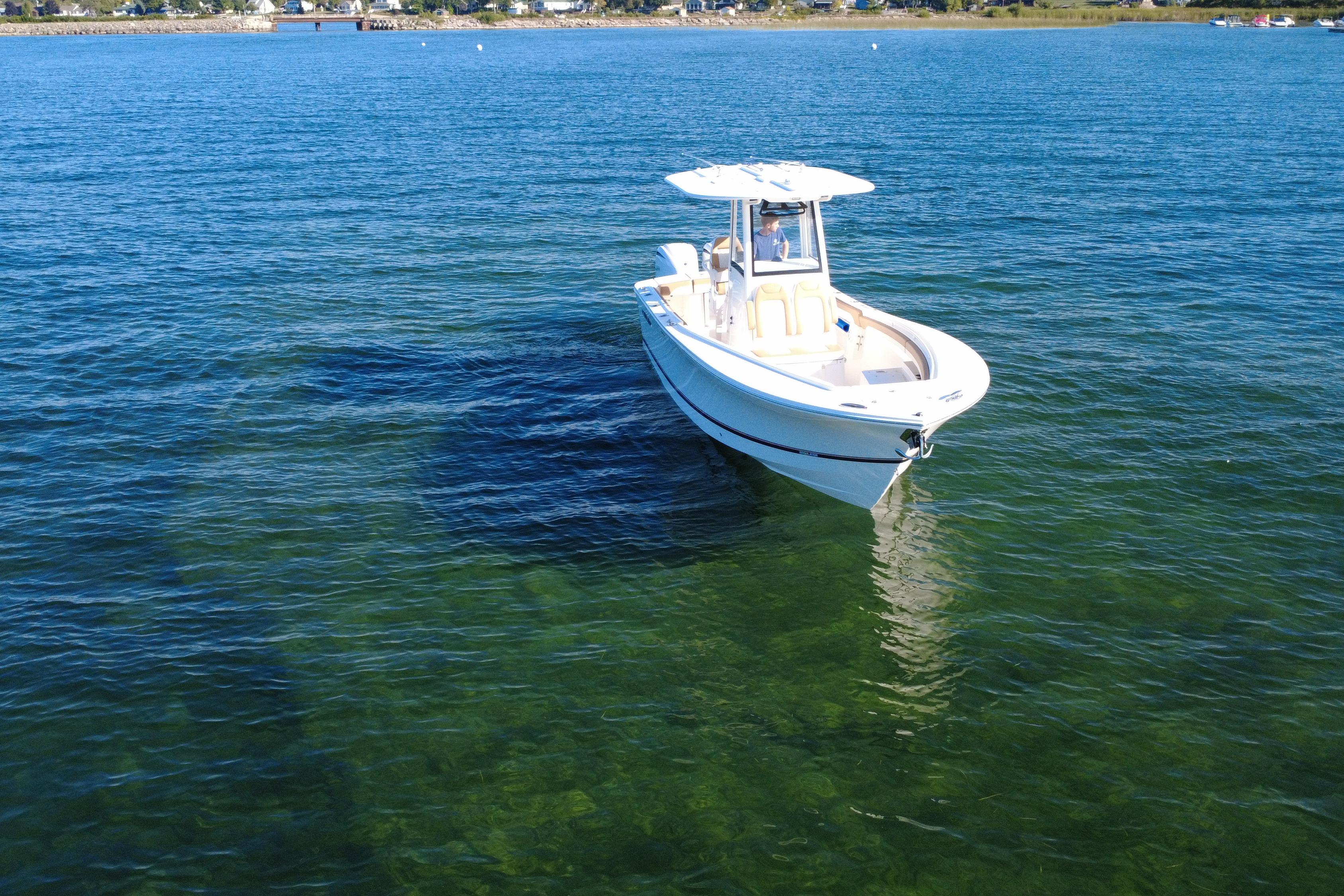 2025 Regulator 25 boat on clear blue water, near shoreline.