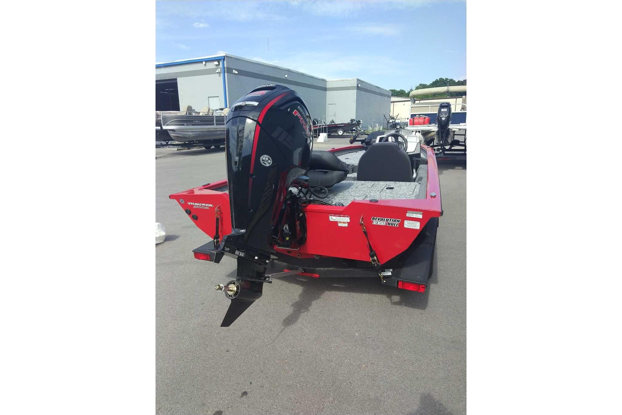 Red 2026 Tracker Pro Team 190 boat with powerful outboard motor, parked outdoors.