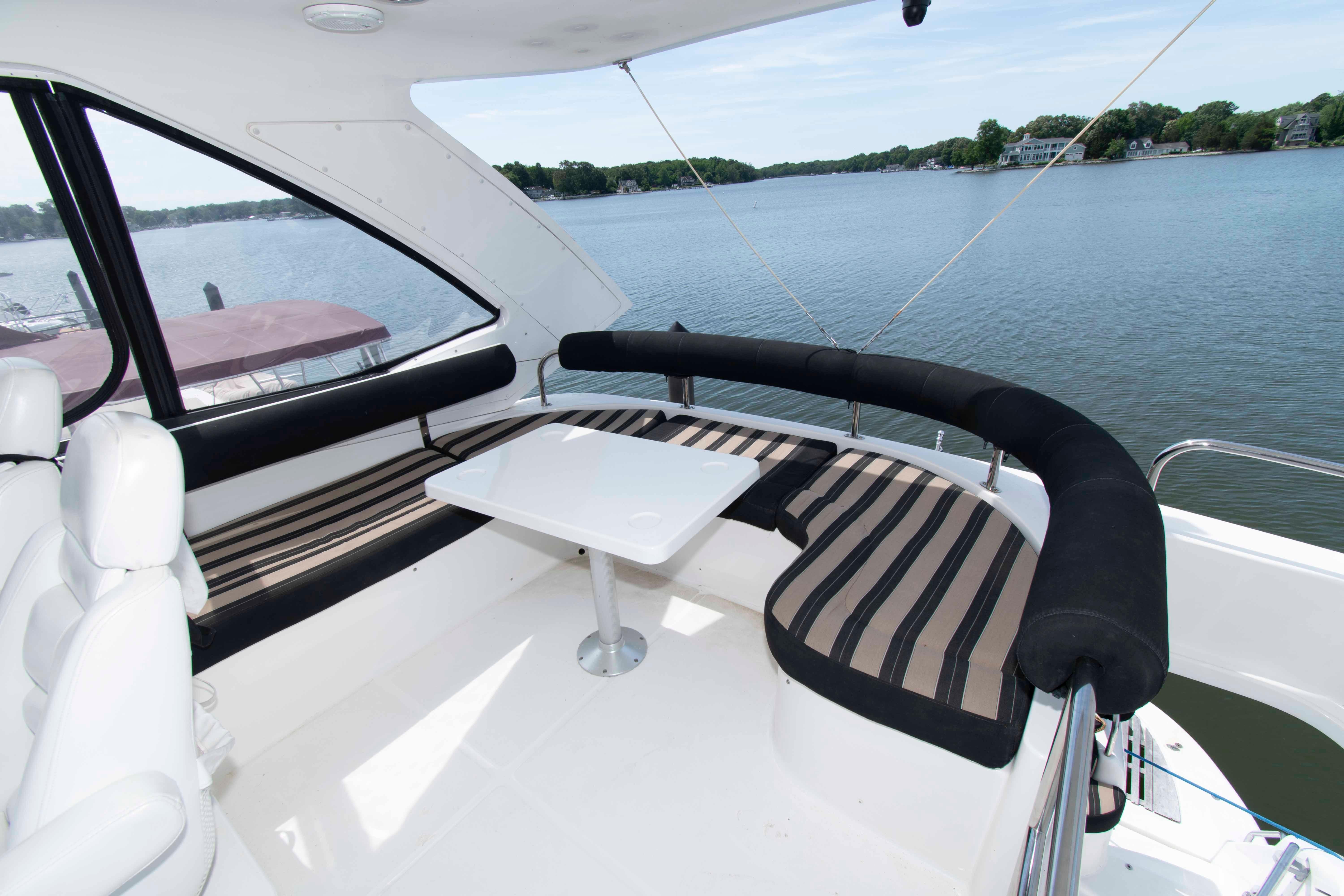 Luxurious 2003 Neptunus 56 Flybridge yacht with elegant seating and scenic water view.