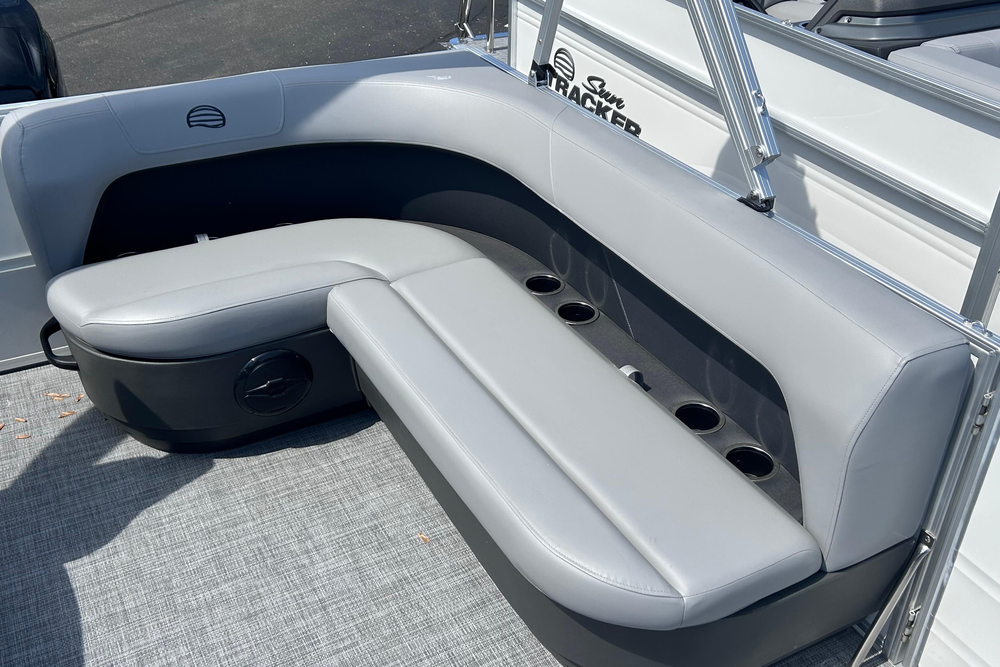 2026 Sun Tracker Party Barge 16 DLX pontoon seating with cup holders, gray upholstery.