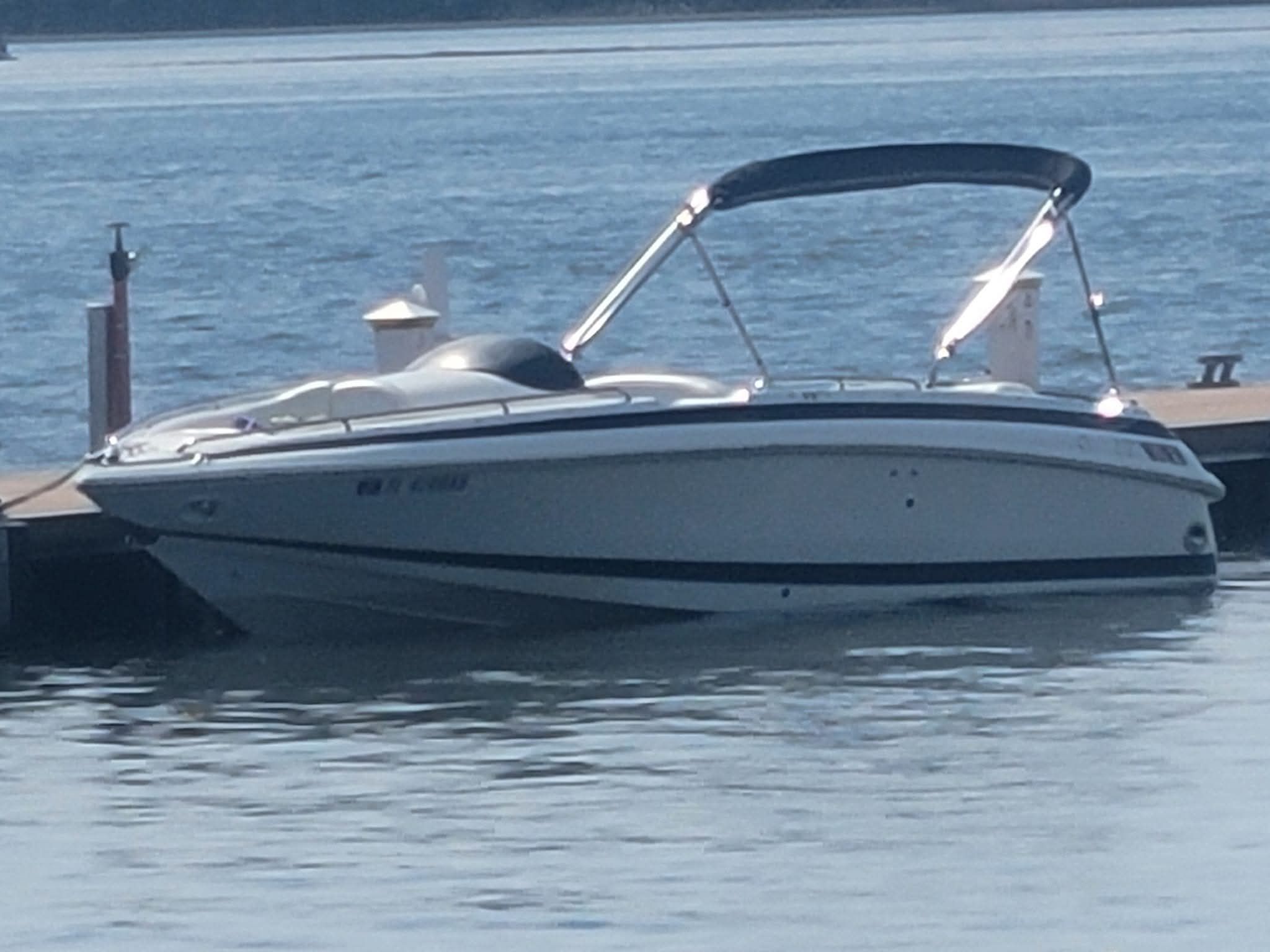 1997 Cobalt 23LS boat docked on calm water.