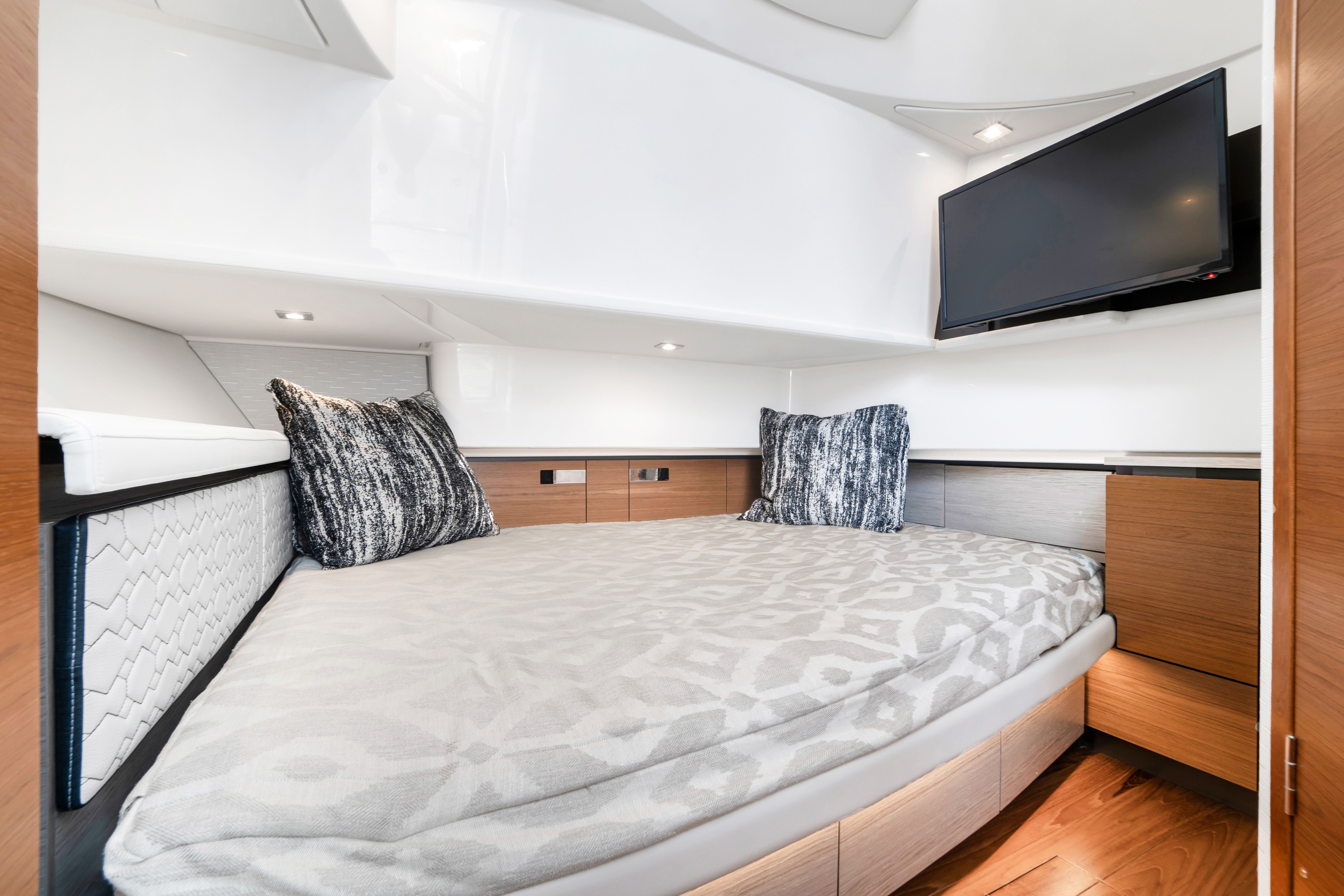 Interior of a 2023 Tiara Yachts 38 LS featuring a cozy bed and a television.