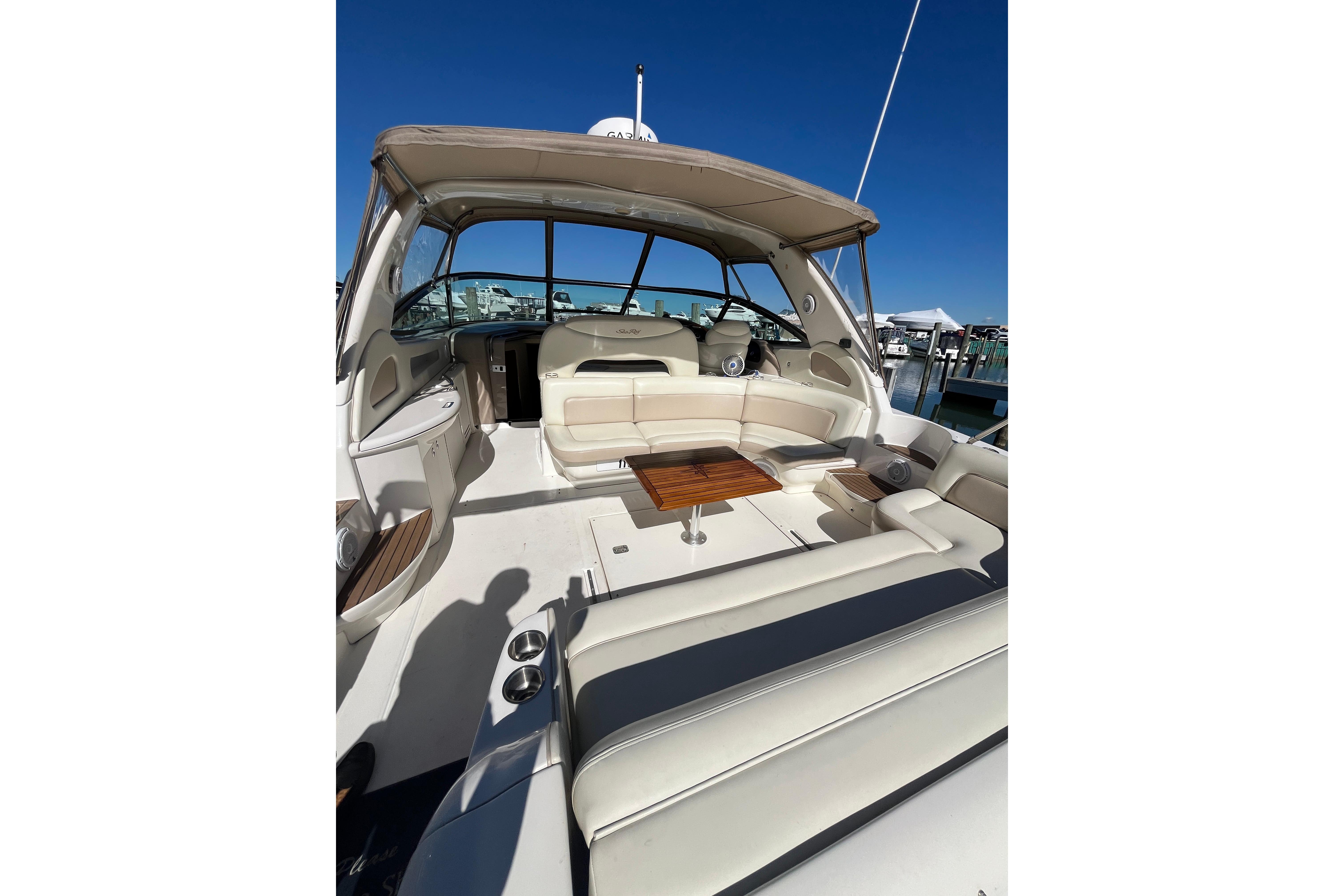 2000 Sea Ray 460 Sundancer yacht interior with seating and table, docked under clear blue sky.