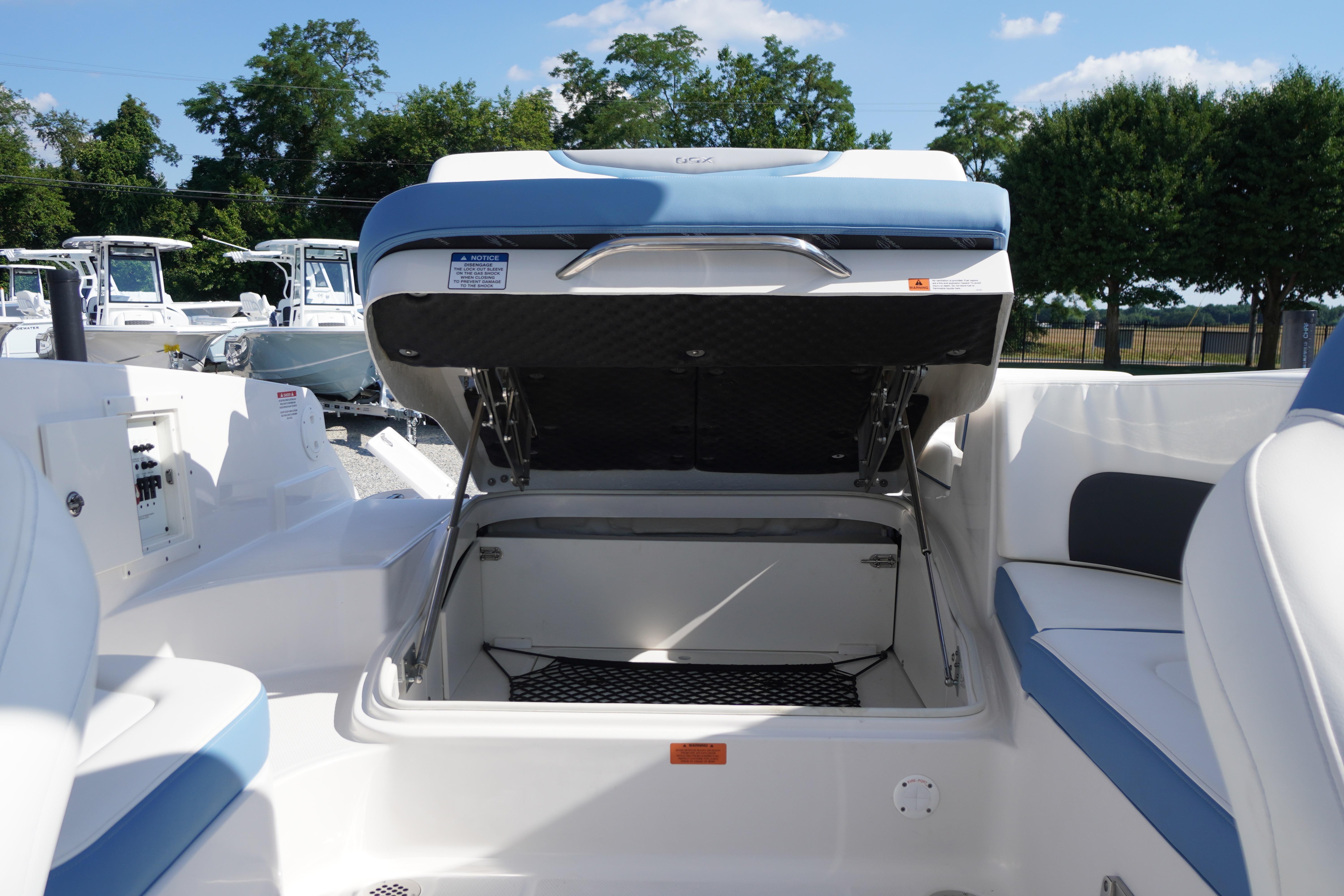 2026 Chaparral 270 OSX boat interior with open storage compartment, showcasing seating and controls.