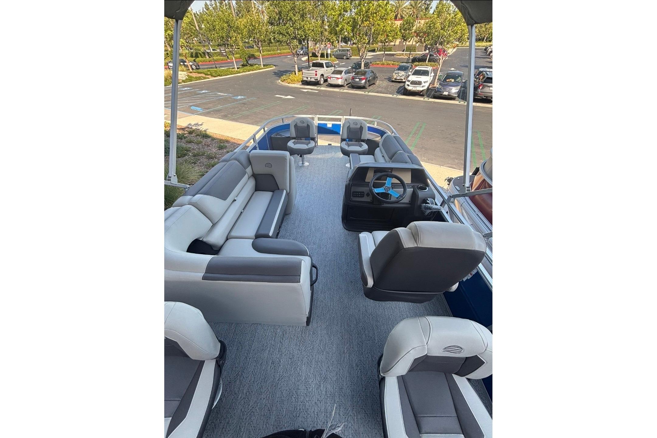 2026 Sun Tracker Fishin' Barge 20 DLX interior with seating and steering console.