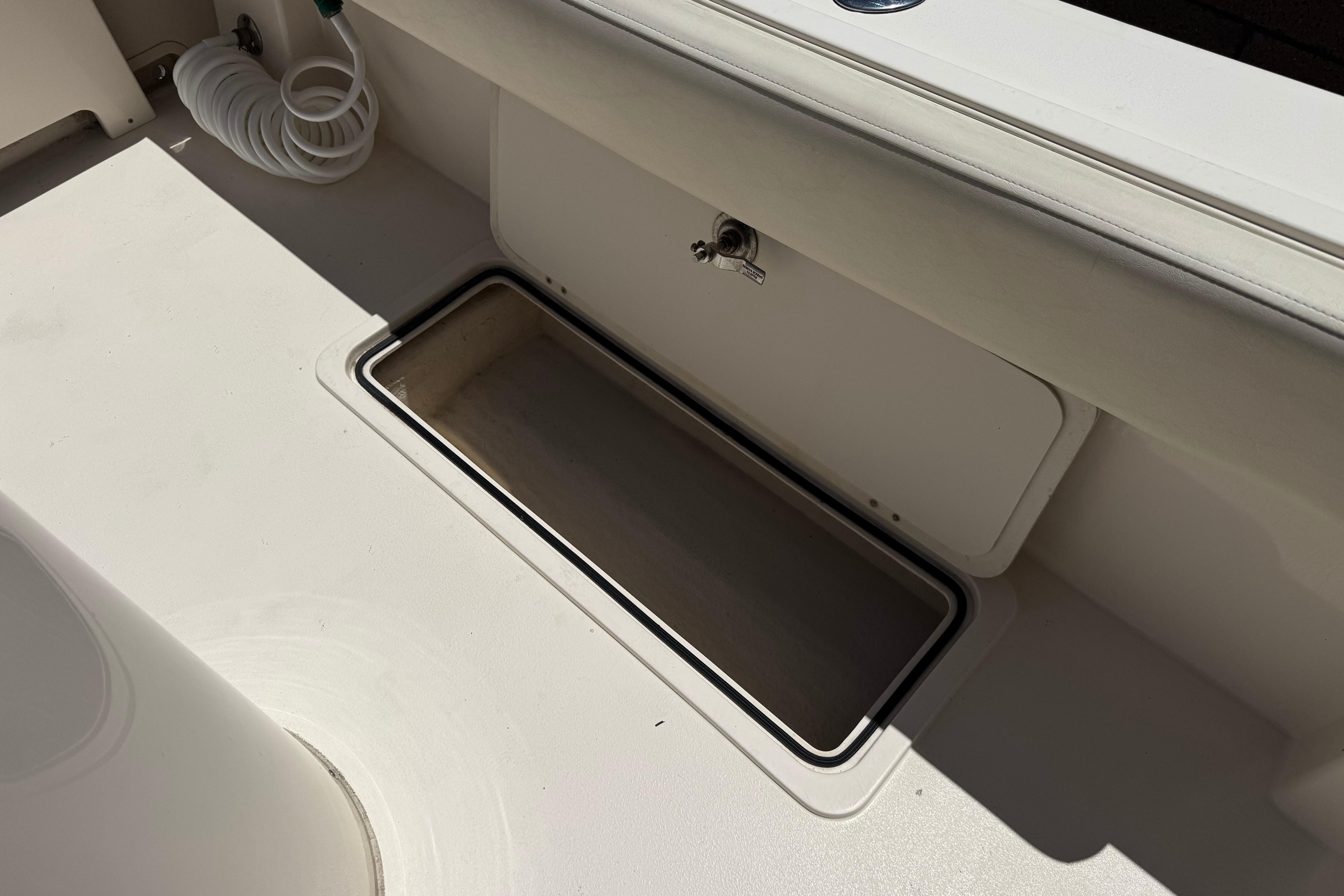 2017 Defiance Admiral 220 EX boat deck with storage compartment and hose.