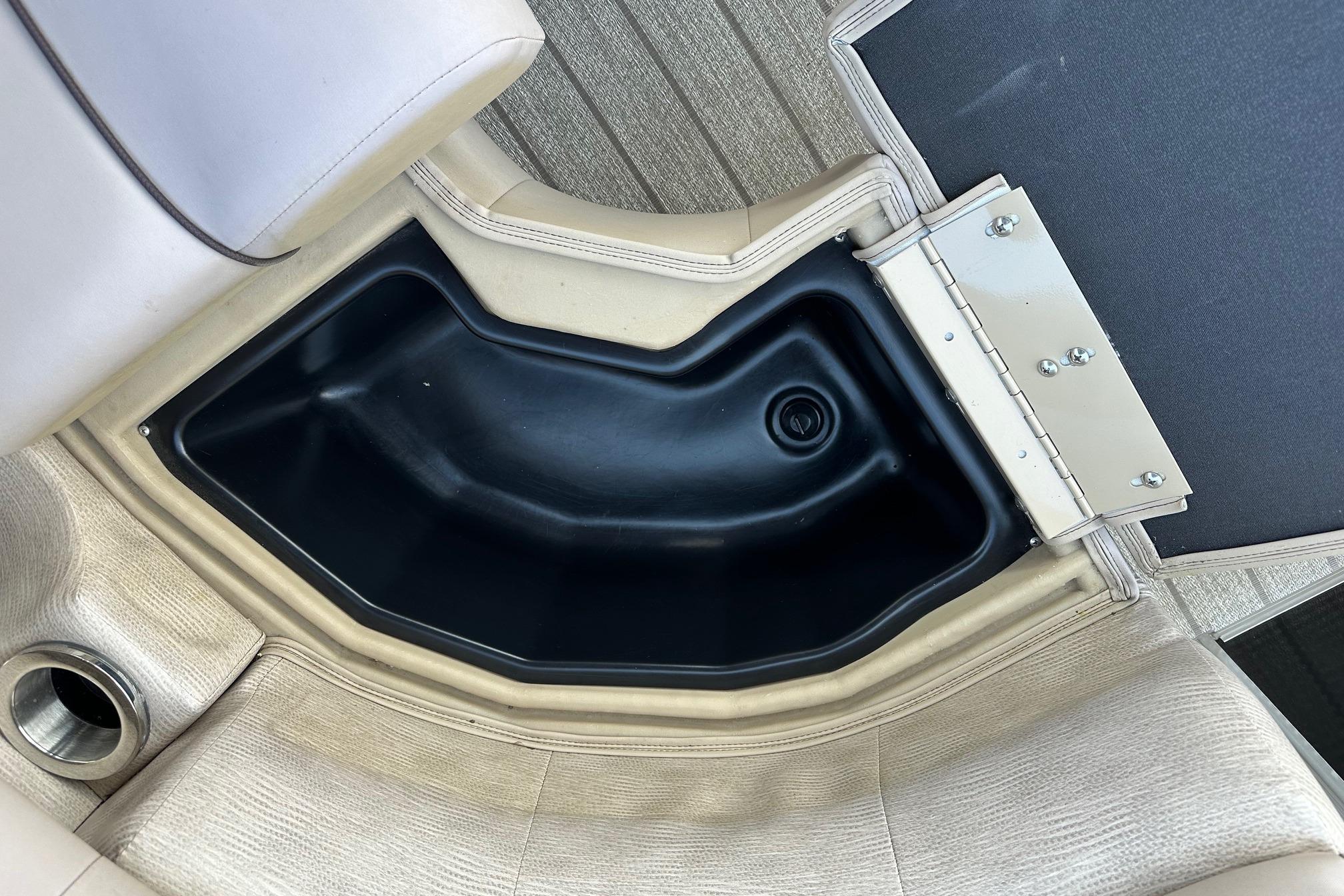 Storage compartment in 2017 Bennington 22 GPD boat with beige seating and black interior.