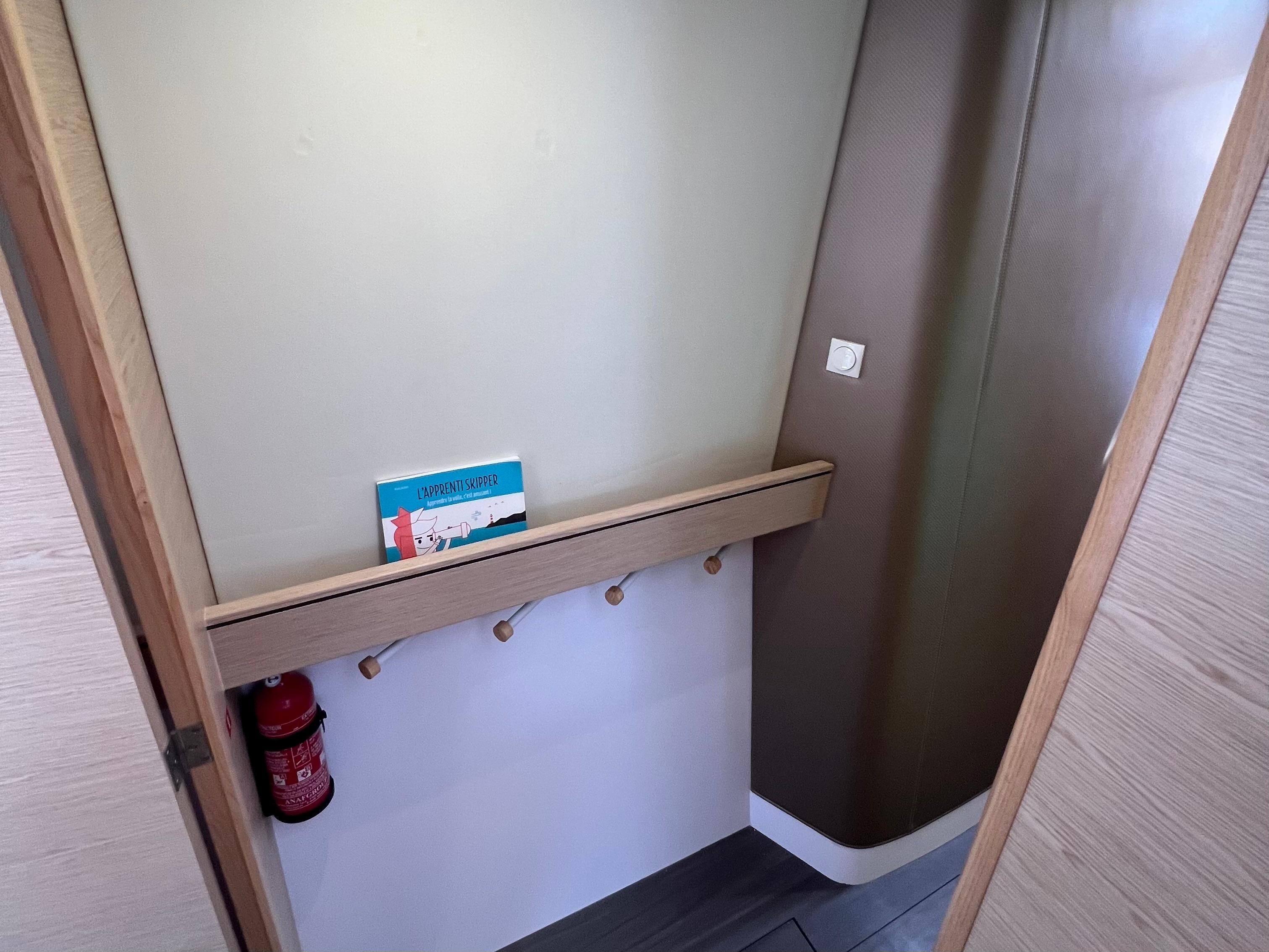 2024 Outremer 45 interior hallway with fire extinguisher and brochure.