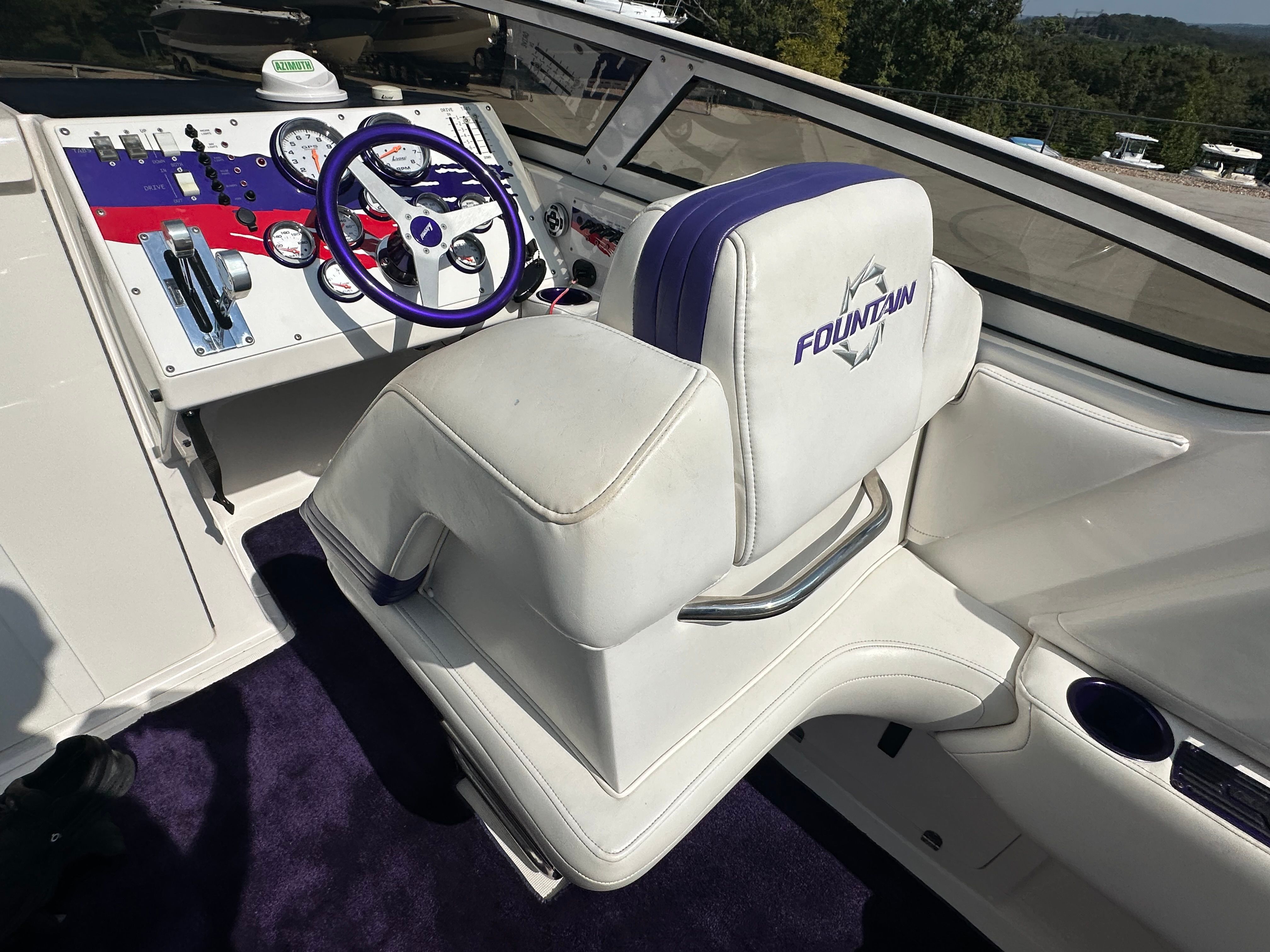 The image shows the cockpit of a 2006 Fountain 29 Fever boat with purple accents.