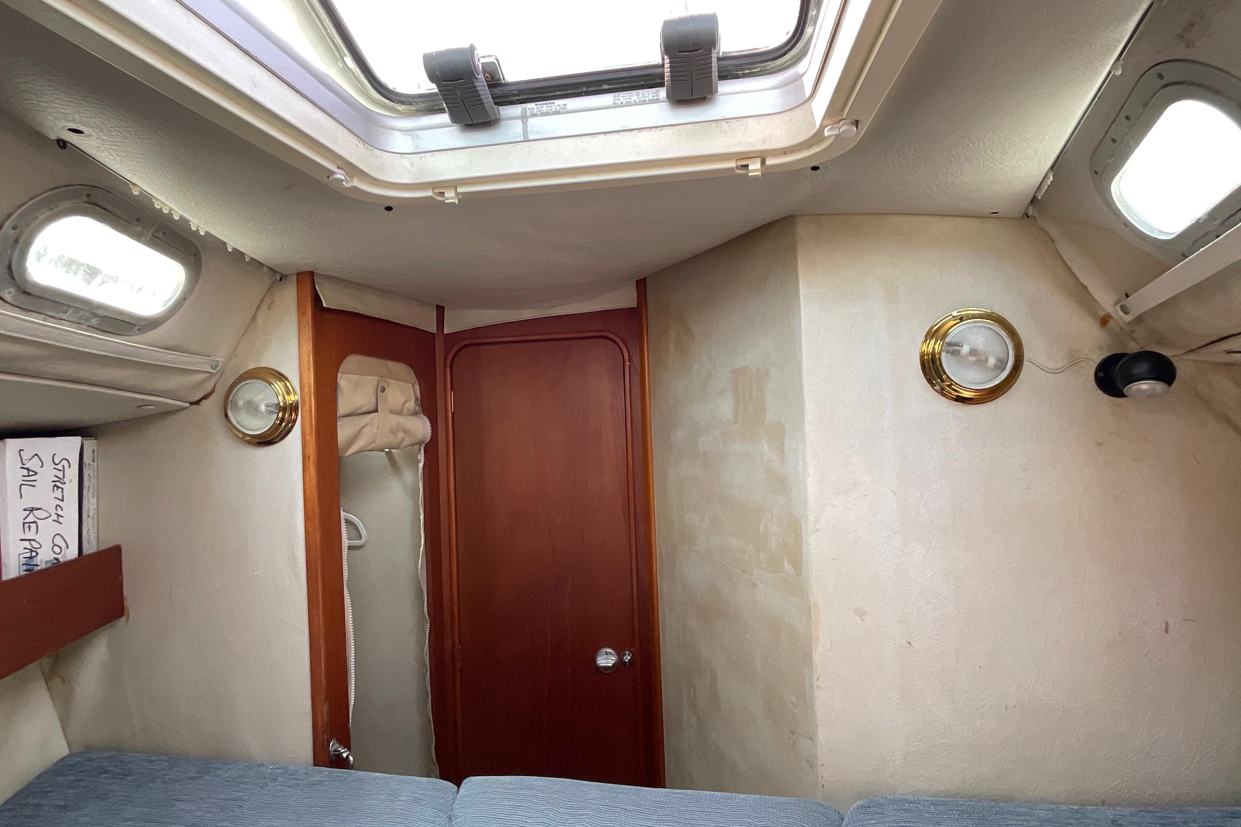 Interior cabin of 1988 Westerly Corsair 36 sailboat with wooden door and portholes.