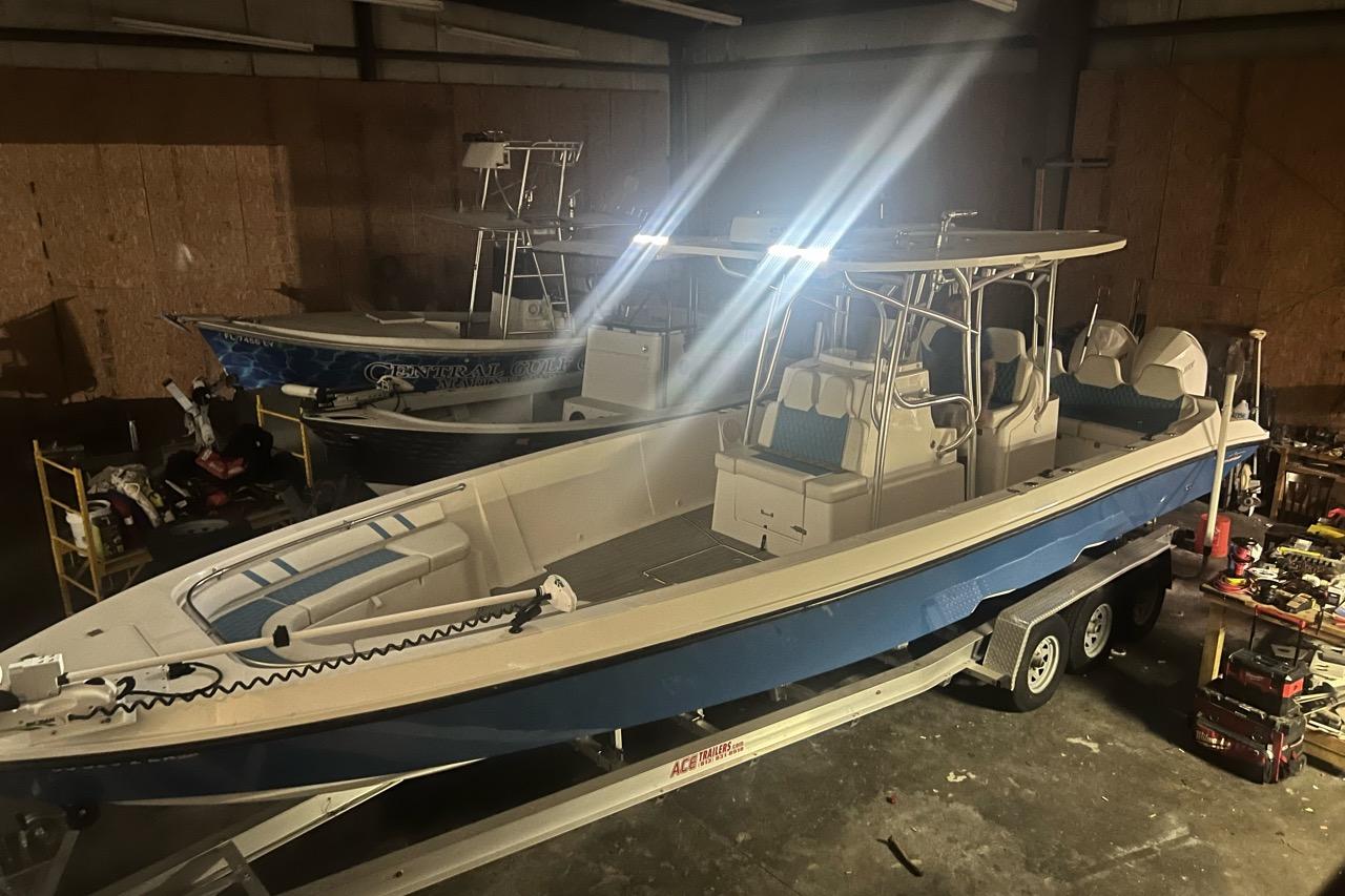 2021 Custom Infusion 34 CC boat in a dimly lit garage on a trailer.