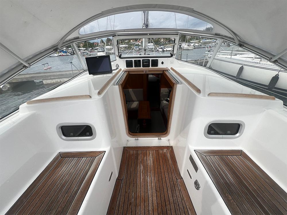 2023 Hallberg-Rassy 340 yacht cockpit with wooden flooring and navigation equipment.