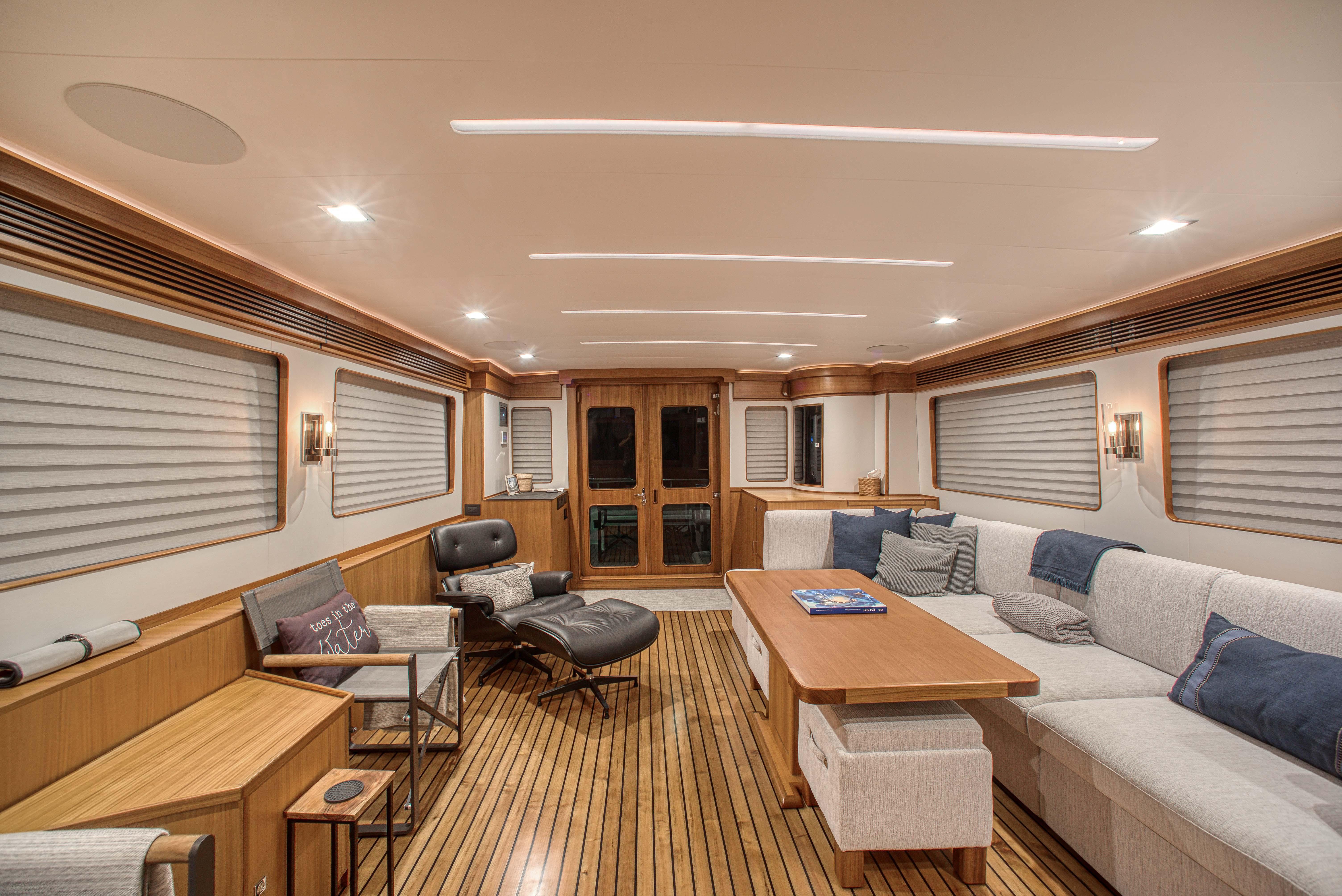 Luxurious interior of 2023 Marlow Explorer 70E-CB yacht with elegant seating and wooden flooring.