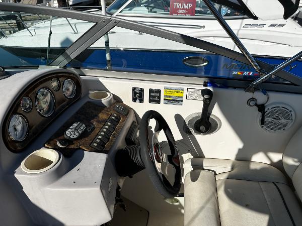 2004 Rinker Fiesta Vee 250 boat cockpit with steering wheel and control panel.