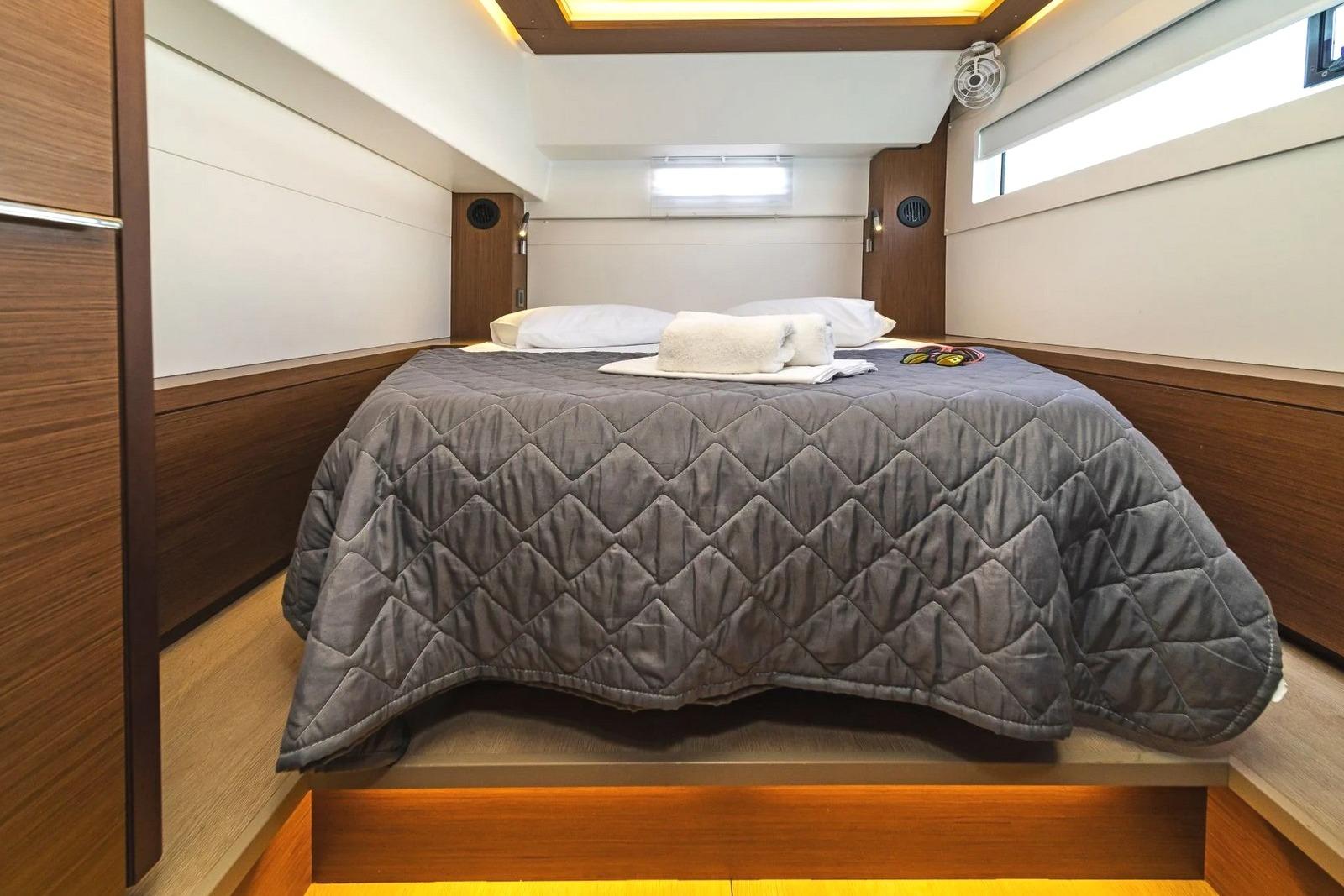 Luxurious cabin interior of 2021 Lagoon 46 yacht with cozy bedding and modern design.