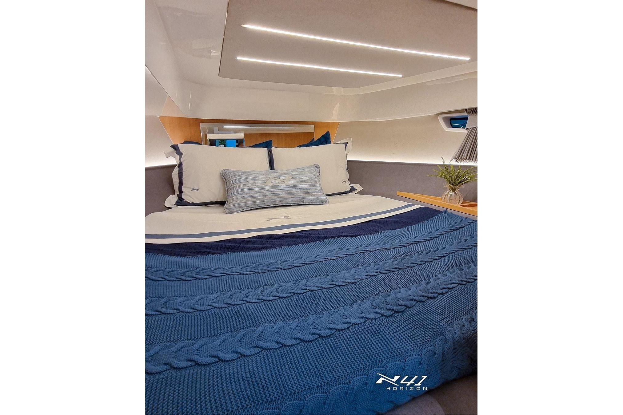 Luxurious cabin interior of 2025 NX Boats NX41 HORIZON with blue bedding.