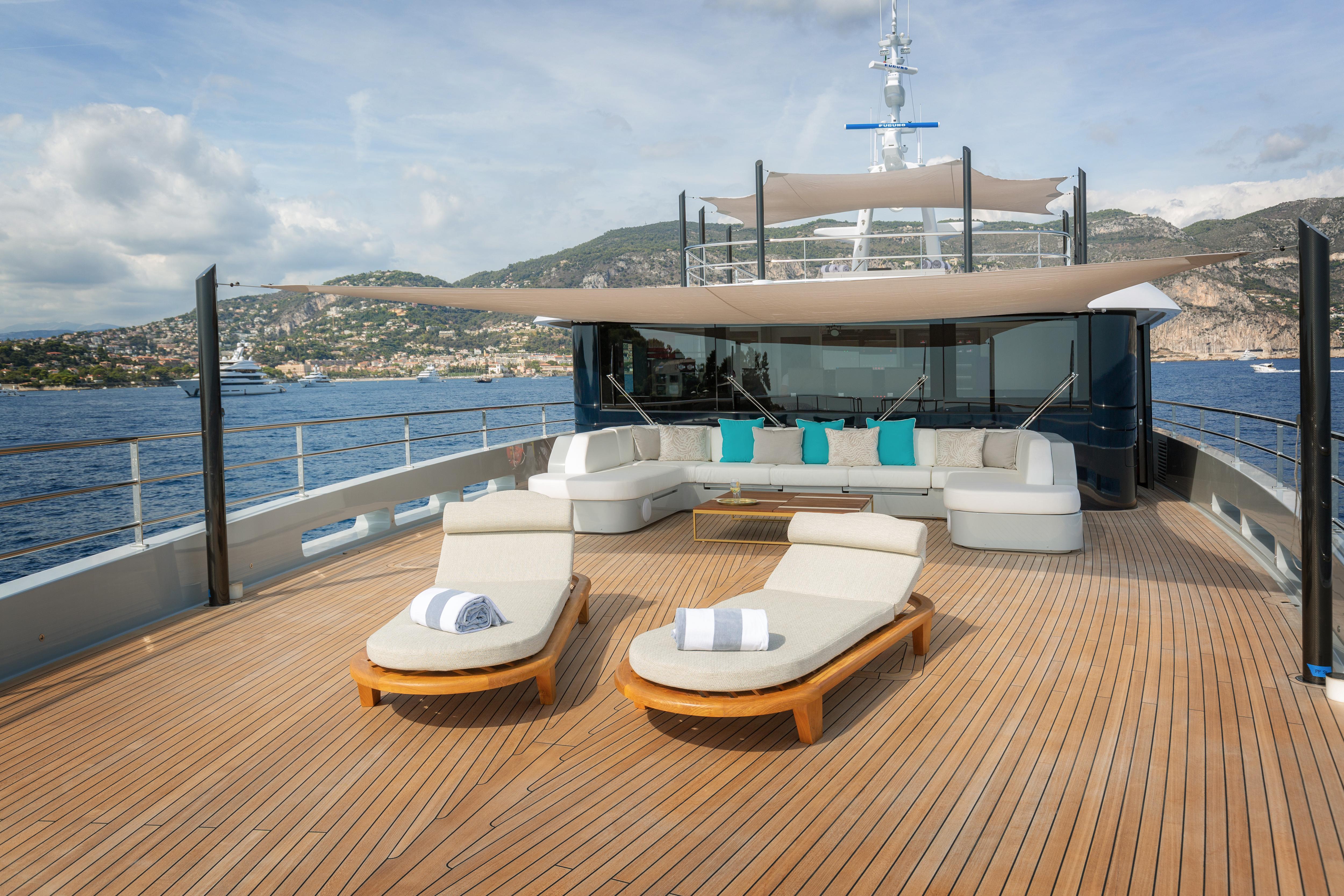 Luxurious Versilcraft HS 2022 yacht deck with sun loungers and scenic ocean view.
