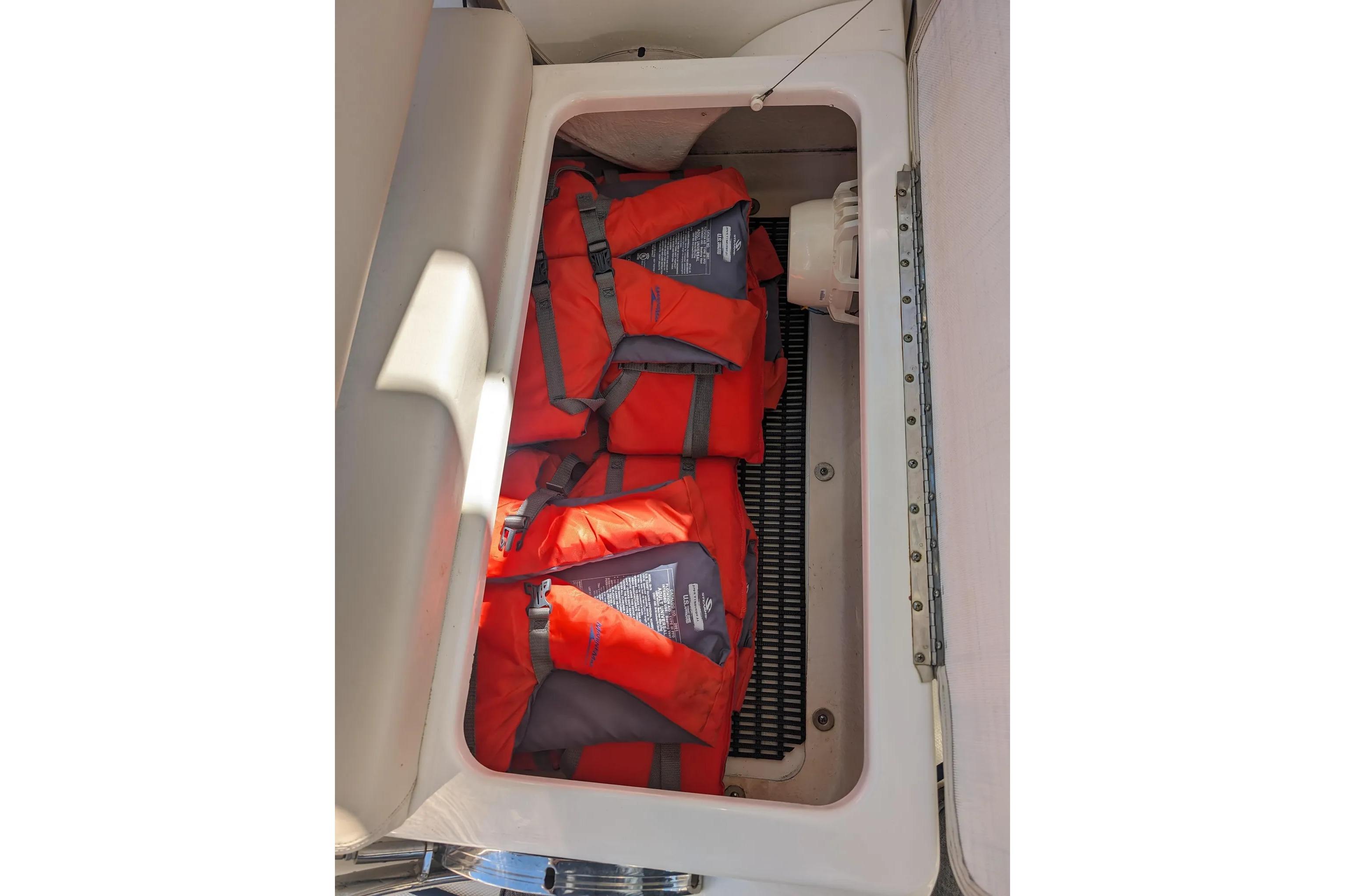 Storage compartment with orange life jackets on a 2017 Boston Whaler 320 Vantage boat.