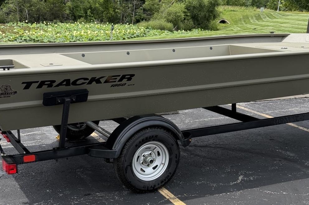 2026 Tracker Grizzly 1860 Utility boat on trailer, parked outdoors.