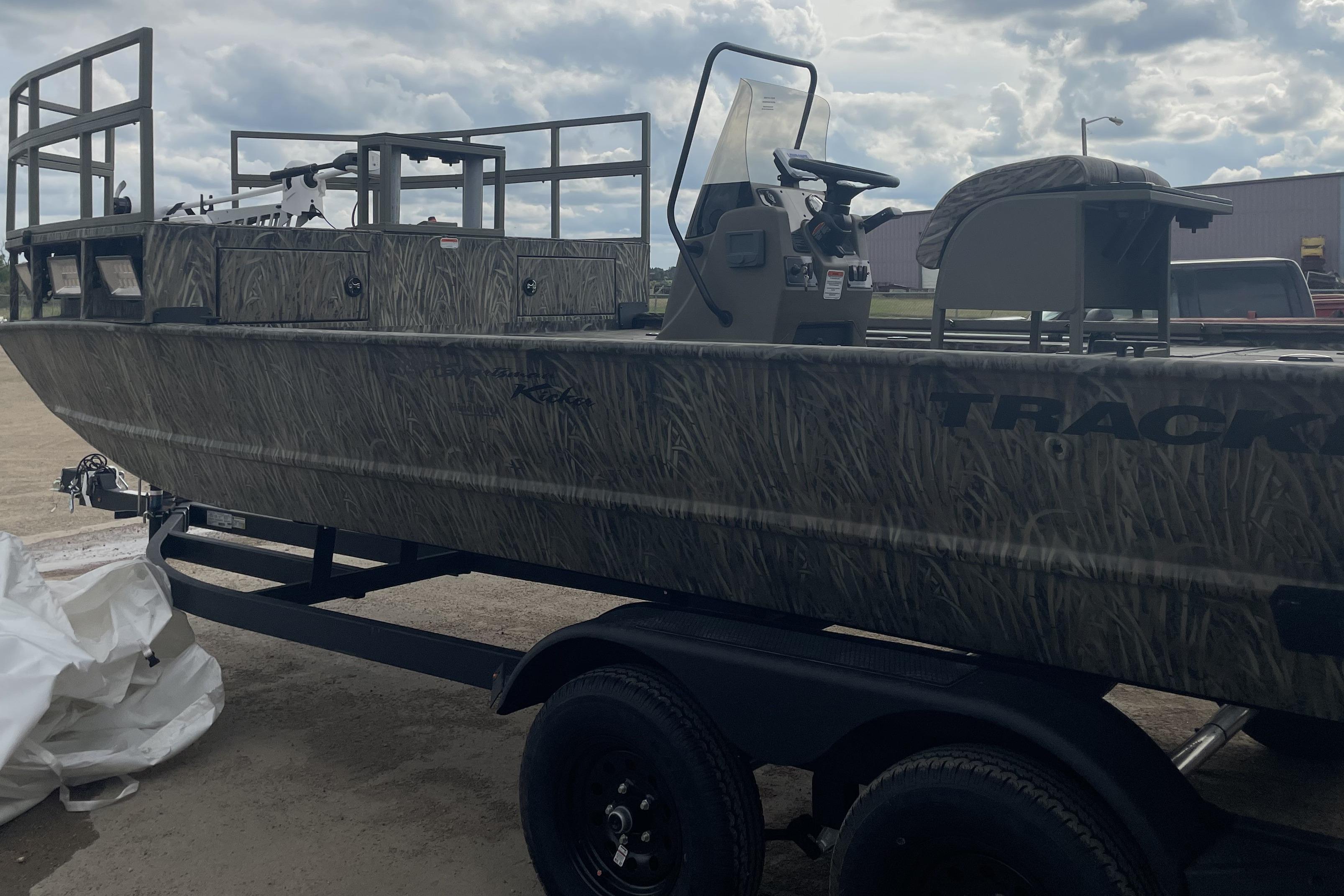 2026 Tracker Grizzly 2072 CC Sportsman Kicker boat on trailer, camo design, cloudy sky.
