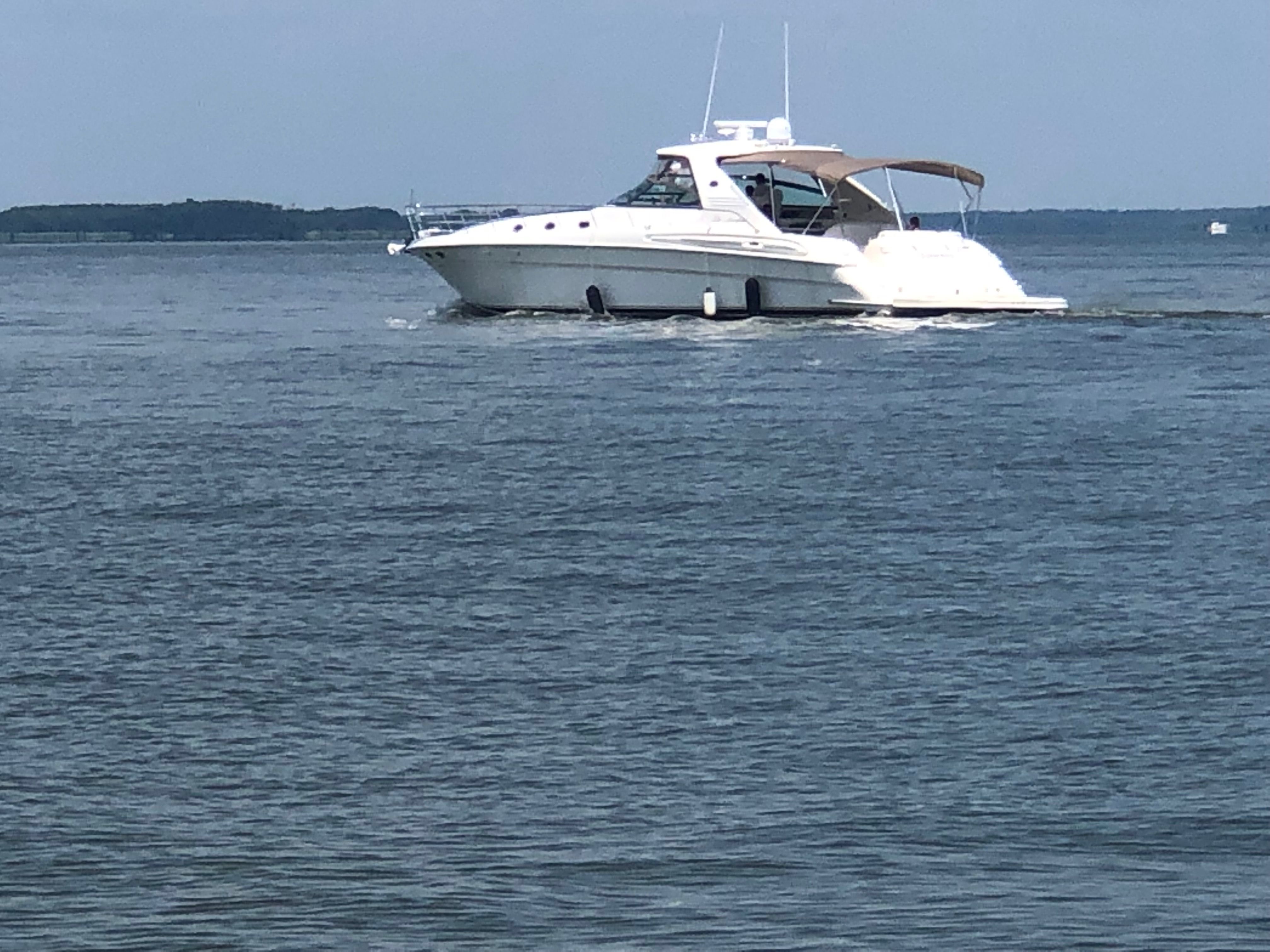 A 2003 Sea Ray S600 Sunsport cruising on calm water under a cloudy sky.
