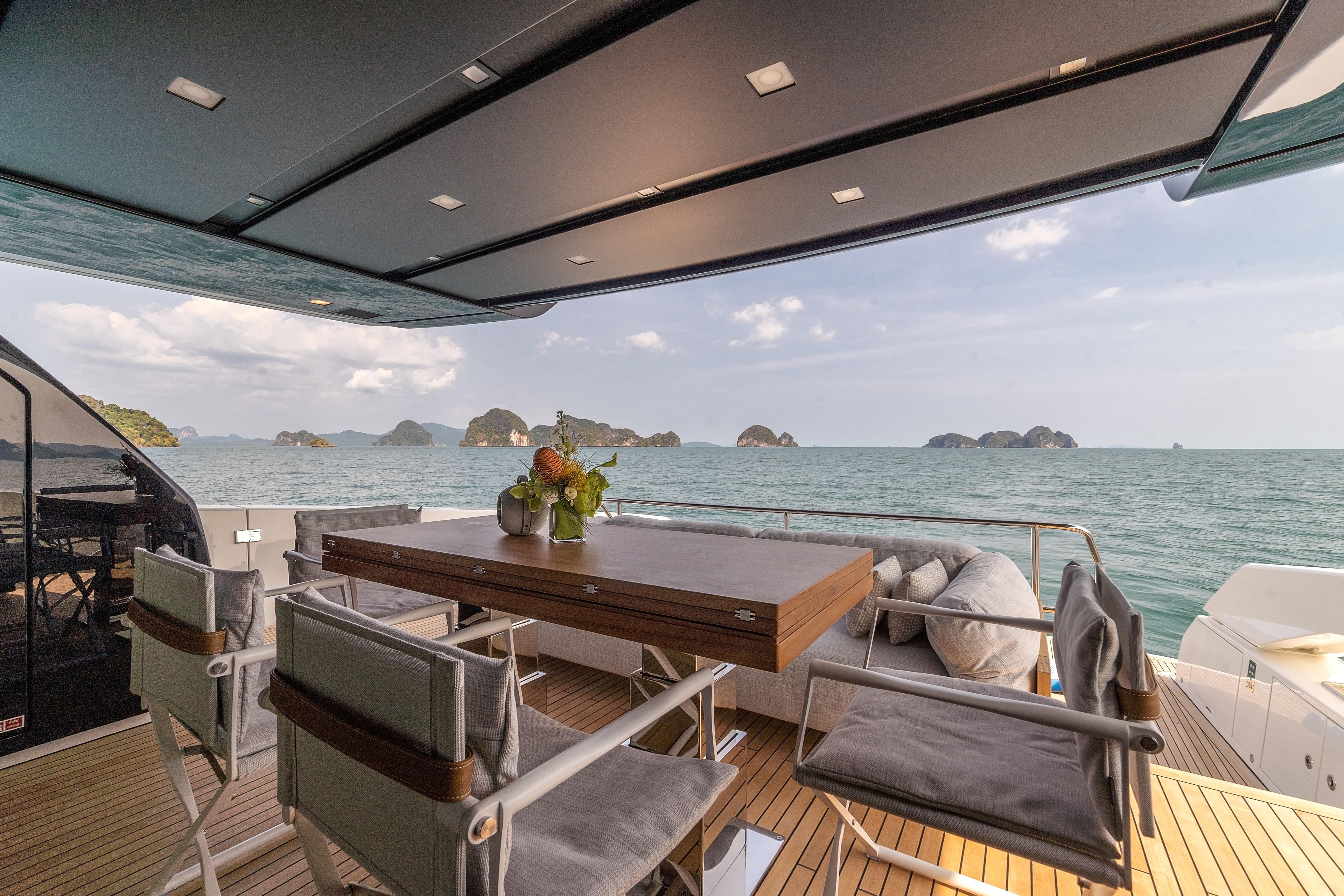 Luxurious 2023 Sanlorenzo SX76 yacht deck with dining area, ocean view, and elegant seating.