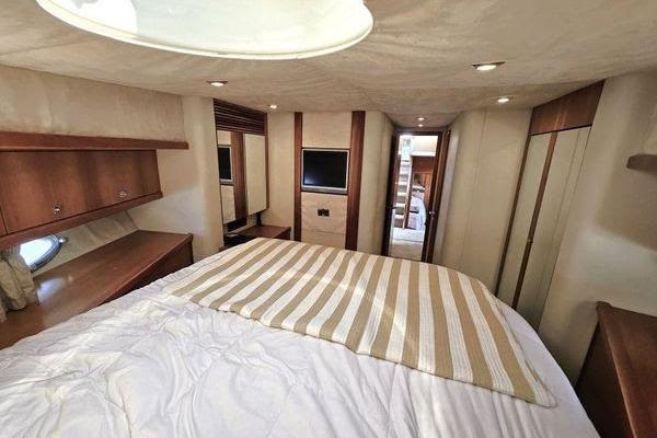 Luxurious bedroom interior of 2005 Sunseeker Manhattan 66 yacht with modern amenities.