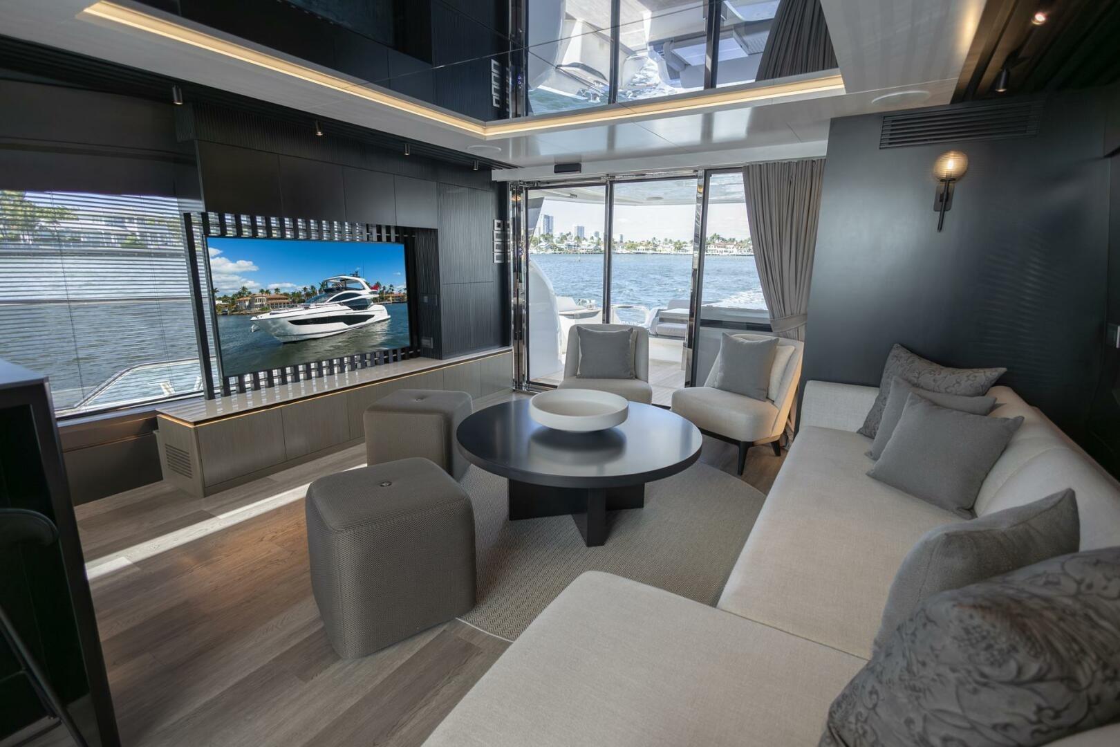 Luxurious interior of 2023 Pearl 72 yacht with modern seating and large window views.