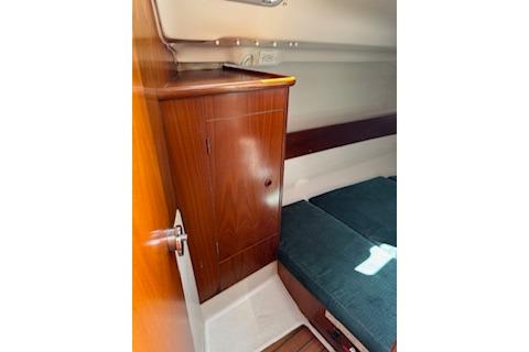 Interior cabin of 2000 Beneteau Oceanis 321 sailboat with wooden cabinetry and seating.