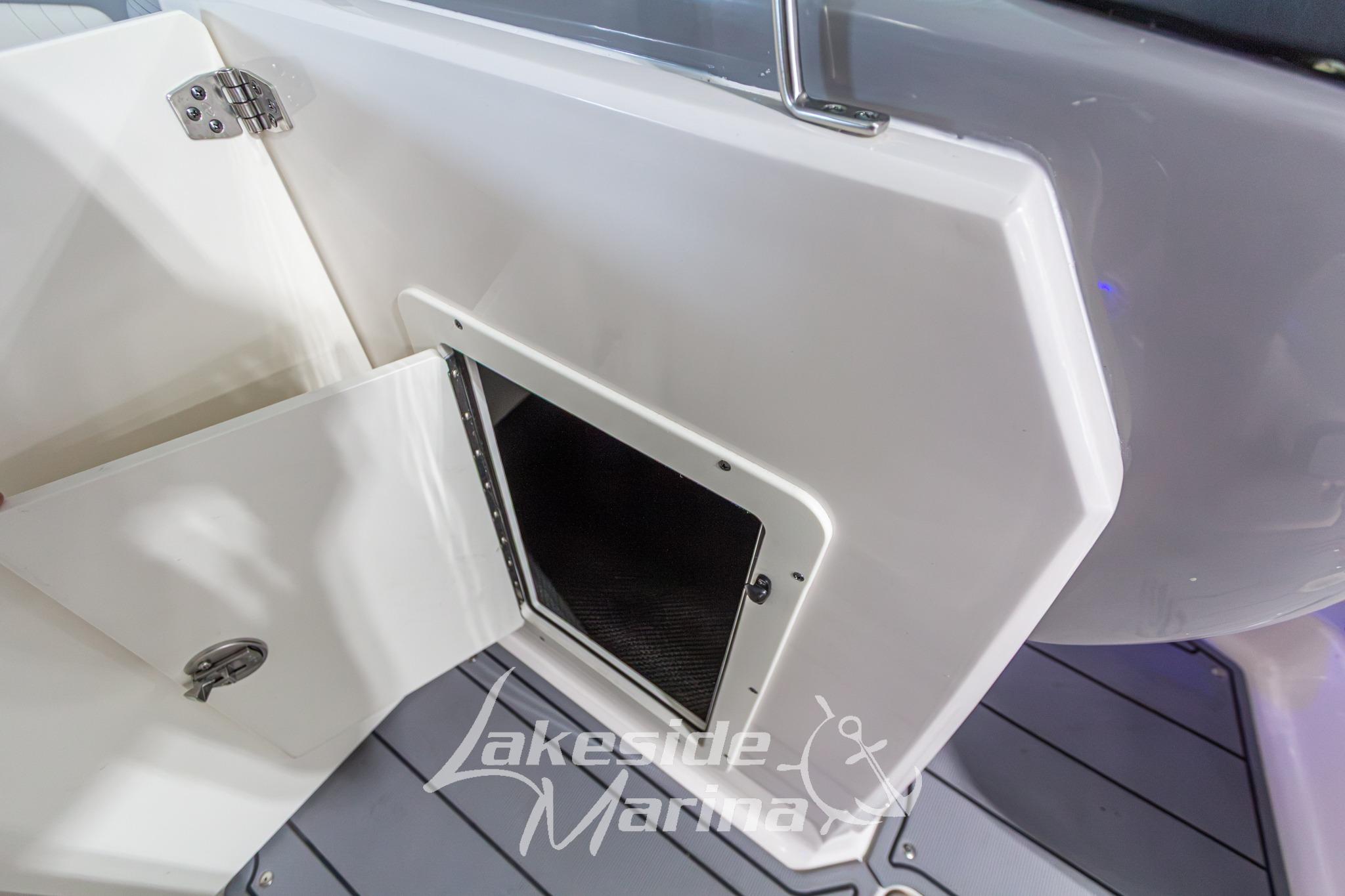 2022 Chaparral 21 SSi boat storage compartment with open hatch, Lakeside Marina branding.