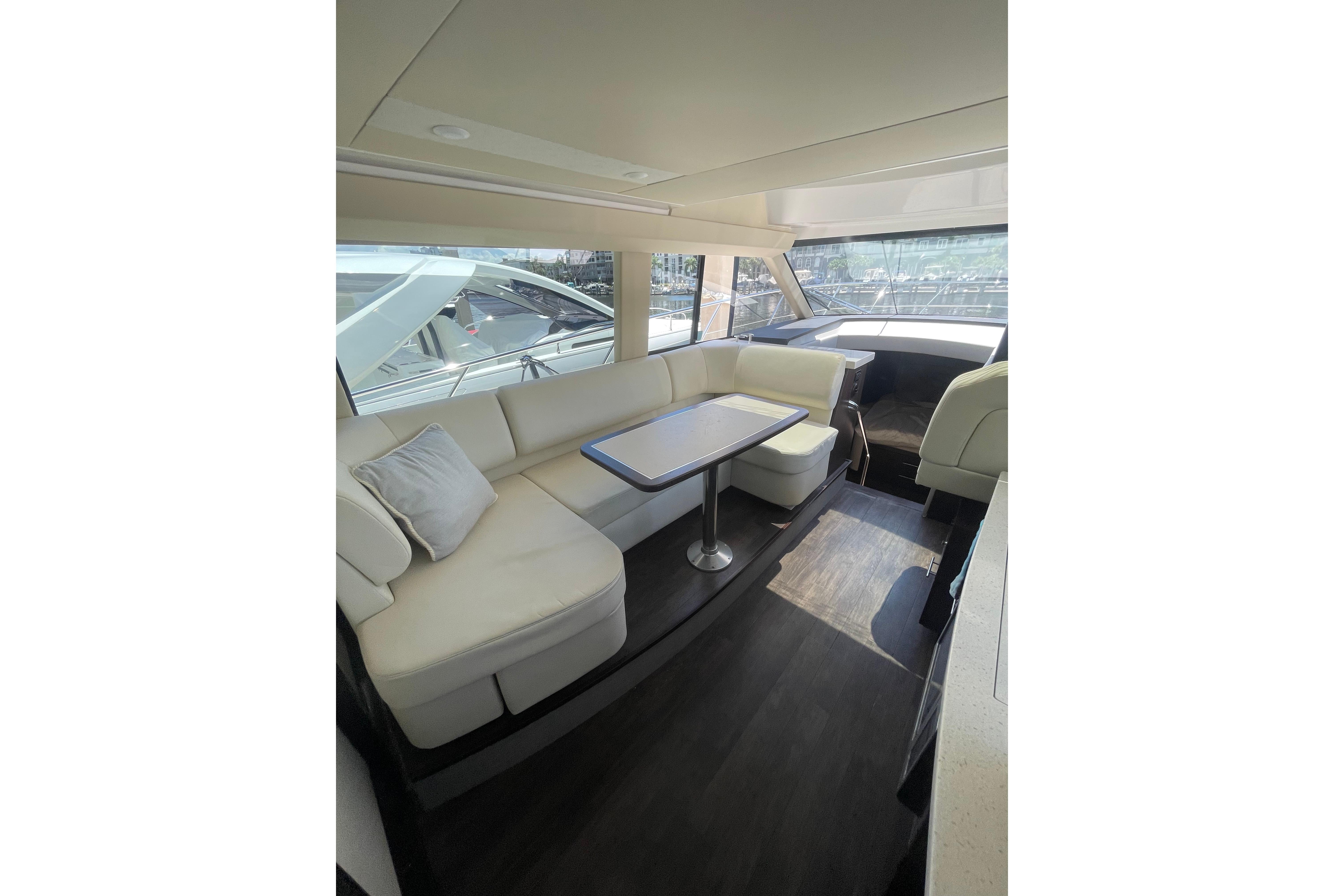 Luxurious interior of 2020 Regal 42 Grande Coupe yacht with elegant seating and table.
