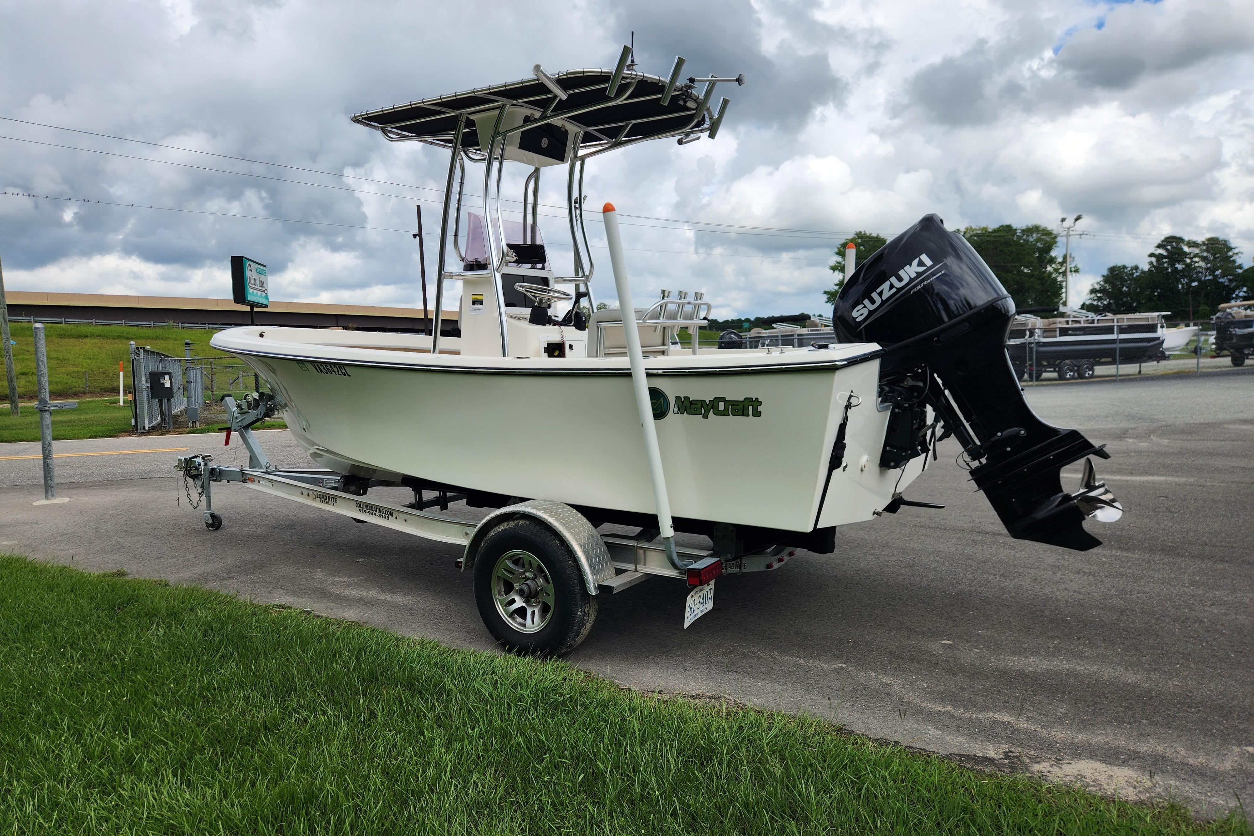 2023 May-Craft 1900CC boat with Suzuki outboard motor on trailer, parked outdoors.